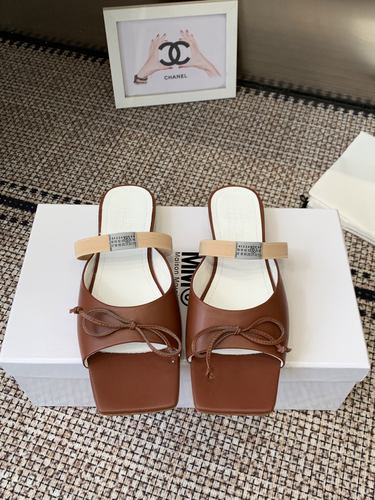 NO:707555,Maison Margiel's 26 spring and summer retro square toe stretch strap ballet shoes, high heels and sandals series adopt the brand's iconic sculptural silhouette that fits the shape of the foot. The upper is soft and smooth, taking into account both fit and design. The square toe + ballet elements are combined with the classic square toe design to create a modern feel. It is paired with the bow decoration on the upper to reconstruct the elegant outline of the ballet shoes. At the same time, it is made into a mules back style, which is both casual and refined.  There is the iconic white single-thread stitching on the heel, and the elastic strap of the shoe body has the MM6 digital logo, which is the key to brand recognition. The empty mule slide structure simplifies the way of putting on and taking off, combining the softness of ballet shoes with the casualness of mule shoes. The upper is retro burst cowhide, the lining is silk sheepskin, the outsole is genuine leather, and the high-heeled model is about 2 cm. Size: 35-41 (customized sizes 40 and 41 are not returnable), slippers, masion  margiela,sandals,high heels,slippers,cowhide,sheepskin,Leather soles19860909Maison Margiel 26春夏款复古方头弹力带芭蕾鞋高跟鞋凉鞋系列 采用品牌标志性的贴合脚型的雕塑感轮廓,鞋面柔软且线条流畅,兼顾贴合度与设计感.方头+芭蕾元素融合经典方头设计打造现代感,搭配鞋面蝴蝶结装饰,重构芭蕾鞋的优雅轮廓,同时做穆勒拖的后空款式,兼具休闲与精致. 鞋后跟处有标志性的白色单线缝线,鞋身弹性带带有MM6数字标识,是品牌辨识度的关键.后空的穆勒拖结构,简化穿脱方式,将芭蕾鞋的柔美与穆勒鞋的随性结合. 鞋面复古爆裂牛皮 内里丝绸羊皮里 大底真皮大底 高跟款约2公分 size :35-41码（40、41码定制不退换）,拖鞋,masion margiela,sandals,high heels,slippers,cowhide,sheepskin,Leather soles,Women's Shoes
