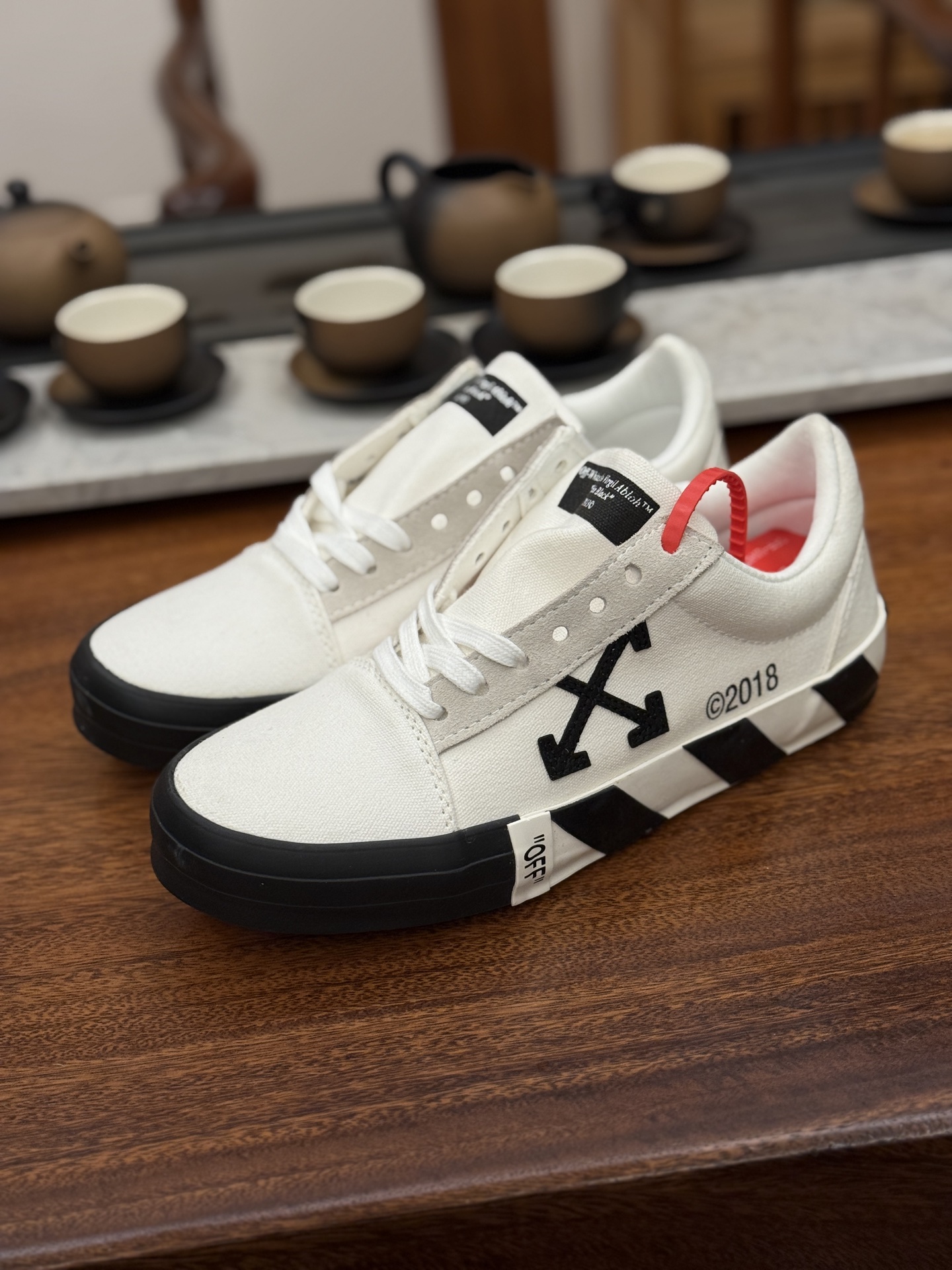 Off-White c/o Virgil Abloh Vulc Low Top 箭头低帮硫化帆布板鞋 尺码:36 37 38 39 40 41 42 43 44 45 46 47 Off-White 近日才发布其春夏新款鞋履,紧跟着就推出全新秋冬鞋款。此番带来的是一系列“ Off-Court ”运动鞋,其中除了基础的黑、白色 Vulc Low-Top 还有一双充满街头韵味的棋盘格元素,亮点其实在鞋内侧的橙色瓶贴以及鞋带头的橙色细节处理。该品牌标志性的箭头标志,防盗扣和鞋带的设计以及鞋后跟的字样也极具“THE TEN”系列的影子。