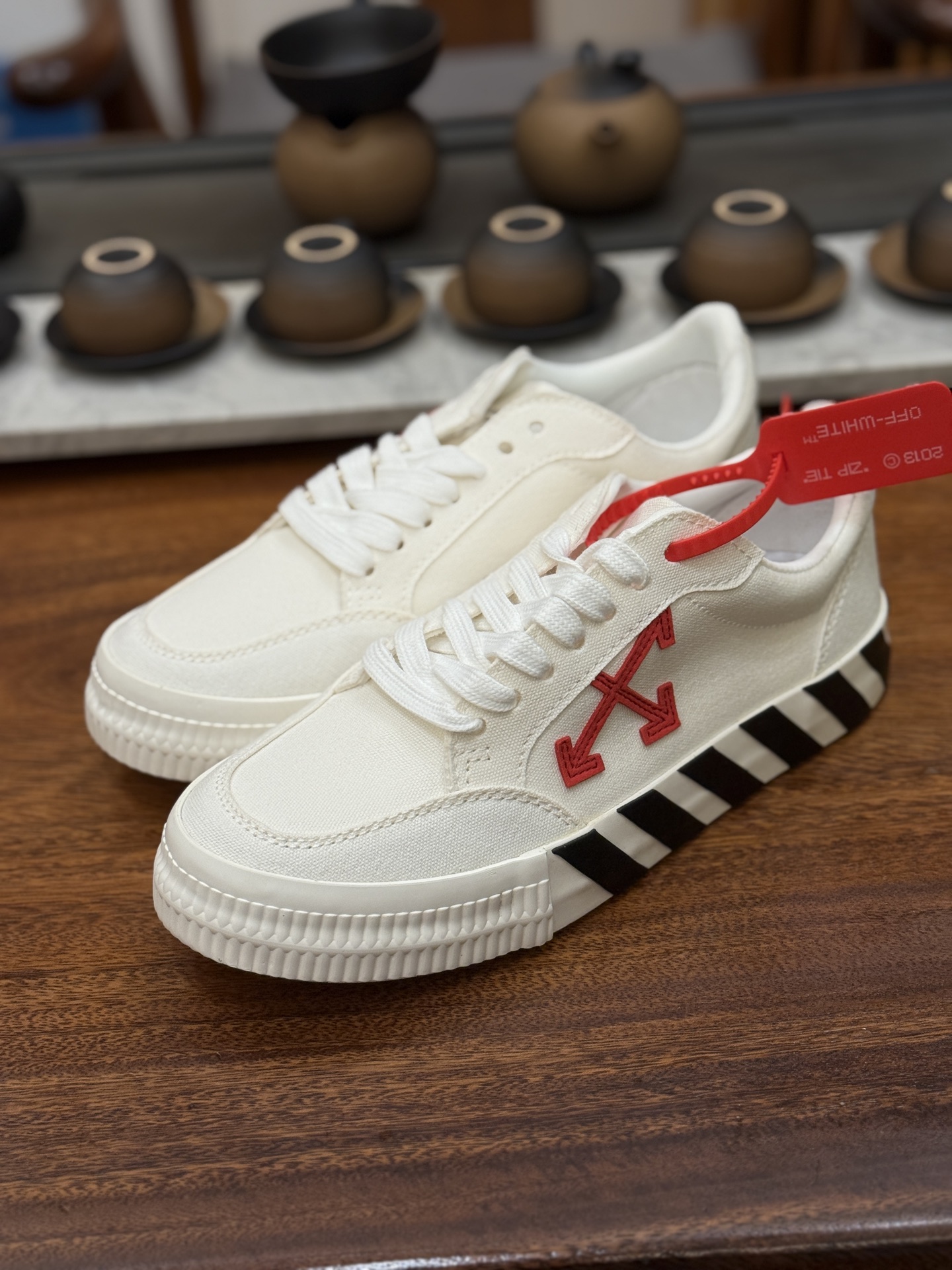 Off-White c/o Virgil Abloh Vulc Low Top 箭头低帮硫化帆布板鞋 尺码:36 37 38 39 40 41 42 43 44 45 46 47 Off-White 近日才发布其春夏新款鞋履,紧跟着就推出全新秋冬鞋款。此番带来的是一系列“ Off-Court ”运动鞋,其中除了基础的黑、白色 Vulc Low-Top 还有一双充满街头韵味的棋盘格元素,亮点其实在鞋内侧的橙色瓶贴以及鞋带头的橙色细节处理。该品牌标志性的箭头标志,防盗扣和鞋带的设计以及鞋后跟的字样也极具“THE TEN”系列的影子。