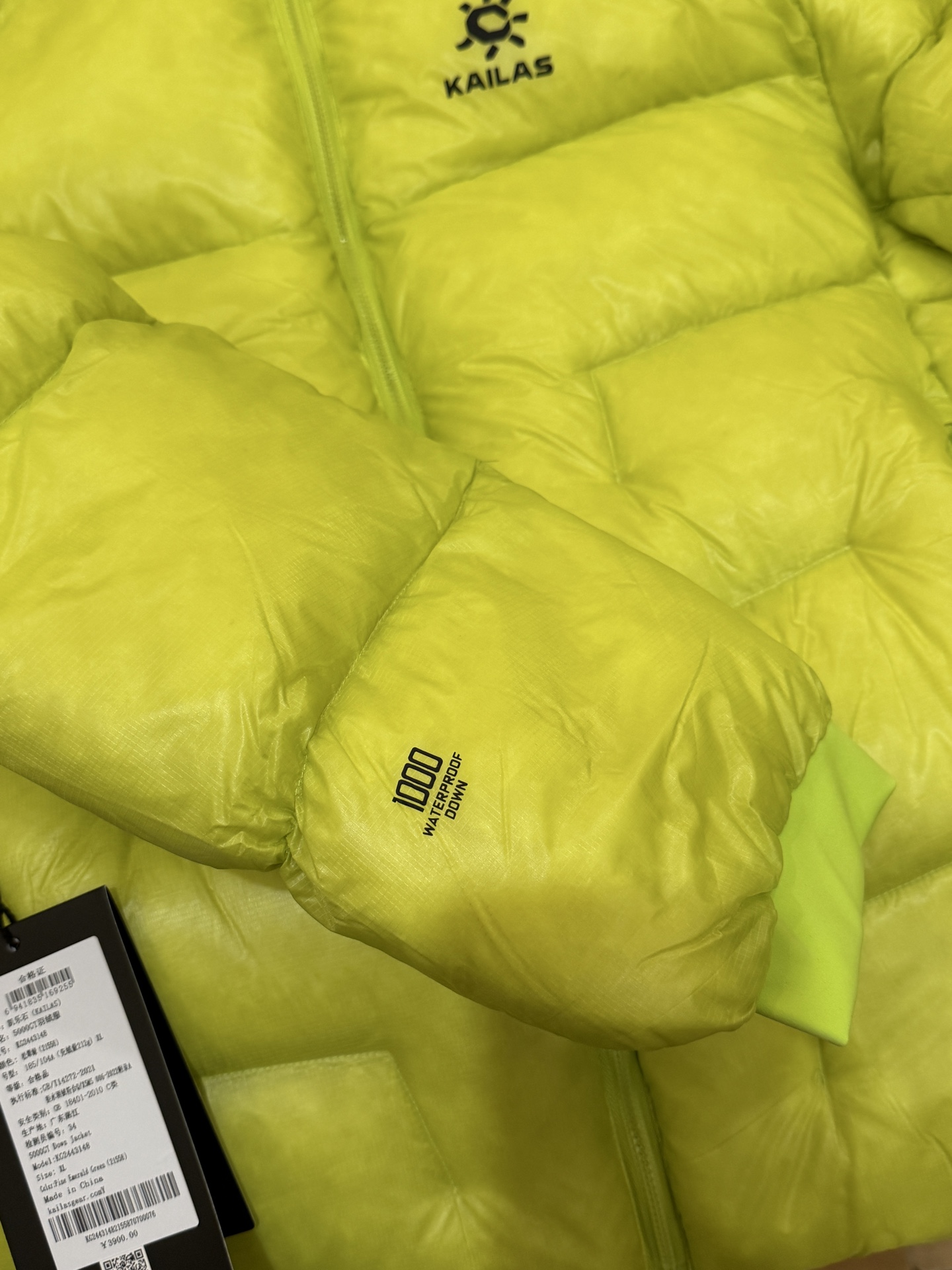 私域版高货!KAILAS 凯乐石 5000GT 颜色 松翠绿 千蓬元帅户外运动登山徒步轻量透气拒水1000蓬羽绒服 超级轻薄半透面料,绒朵透光可见,所以这款填充绒必须足够好,否则没法看! 肉眼可见的超级蓬松,这款因为填充的绒朵好,才能呈现出鼓鼓囊囊的效果,超轻超蓬! 填充国标拒水90白鹅绒(清水绒),支持检测!区别于市面假90绒. 面料为涤纶暗格,市面无同款面料,定制定染色后再做防水;为还原原版质感与手感,打样无数次才最终满意.里布工艺同样复杂,生产周期漫长. 所有五金辅料均为定制定染色:整衣采用三种不同拉链头,内里口袋配特殊色拉链,帽子及下摆抽绳、帽子气眼,均攻克极高工艺难度,完美呈现. 尺码建议:版型偏大,原版数据一刀未改,且可通过下摆内侧抽绳调整至合适效果. 产品配色:松翠绿、玉雪粉、栗色棕、玄铁黑、天池蓝乌木灰