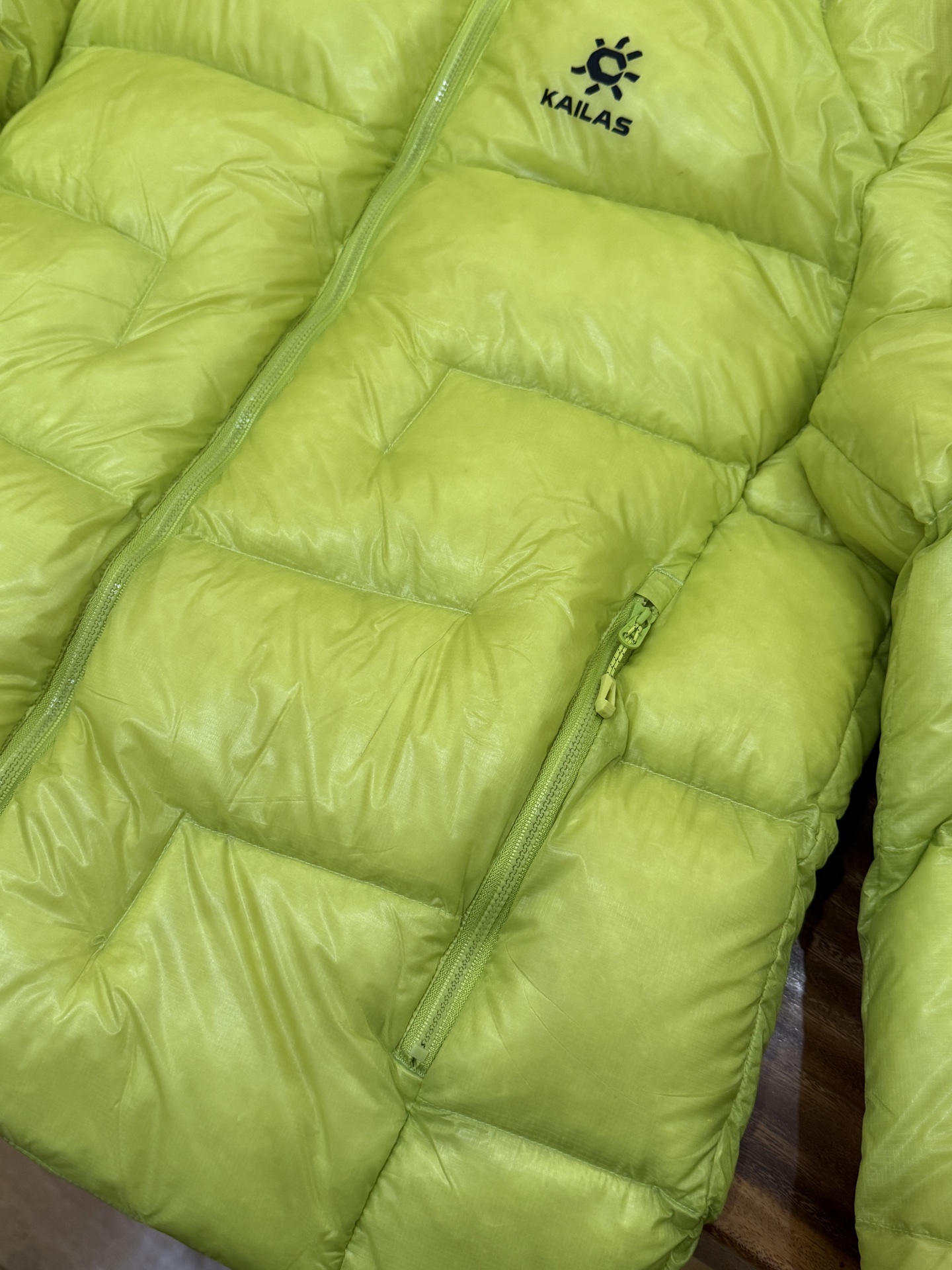 私域版高货!KAILAS 凯乐石 5000GT 颜色 松翠绿 千蓬元帅户外运动登山徒步轻量透气拒水1000蓬羽绒服 超级轻薄半透面料,绒朵透光可见,所以这款填充绒必须足够好,否则没法看! 肉眼可见的超级蓬松,这款因为填充的绒朵好,才能呈现出鼓鼓囊囊的效果,超轻超蓬! 填充国标拒水90白鹅绒(清水绒),支持检测!区别于市面假90绒. 面料为涤纶暗格,市面无同款面料,定制定染色后再做防水;为还原原版质感与手感,打样无数次才最终满意.里布工艺同样复杂,生产周期漫长. 所有五金辅料均为定制定染色:整衣采用三种不同拉链头,内里口袋配特殊色拉链,帽子及下摆抽绳、帽子气眼,均攻克极高工艺难度,完美呈现. 尺码建议:版型偏大,原版数据一刀未改,且可通过下摆内侧抽绳调整至合适效果. 产品配色:松翠绿、玉雪粉、栗色棕、玄铁黑、天池蓝乌木灰