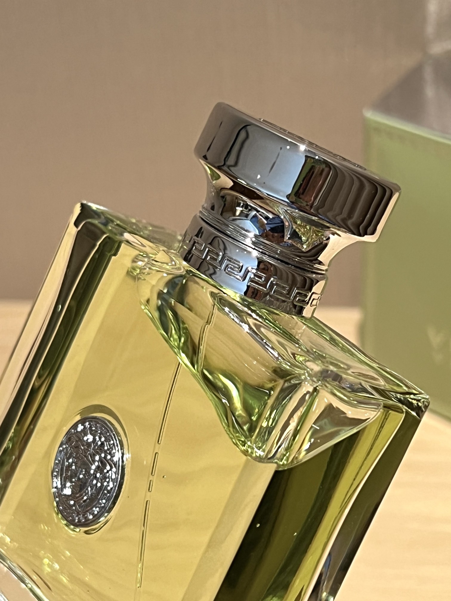 A polished silver-tone Versace logo is centered on the bottle - Comprehensive 3