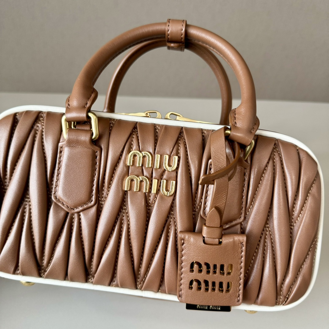 😘M家新品🍒 5BB142焦糖白边,M家新款保龄球包包,官网主推,今年绝对爆🔥款式,顶级进口小羊皮,Miu家独具风格Matelasse图案,包身精致立体有型,正面刻字徽标与皮革颜色相呼应,可拆卸可调节皮革长肩带,棉质缎面衬里,配拉链式口袋,众多明星网红同款,尺寸22 x 10.5 x 7.5Cm,配原版包装🎁