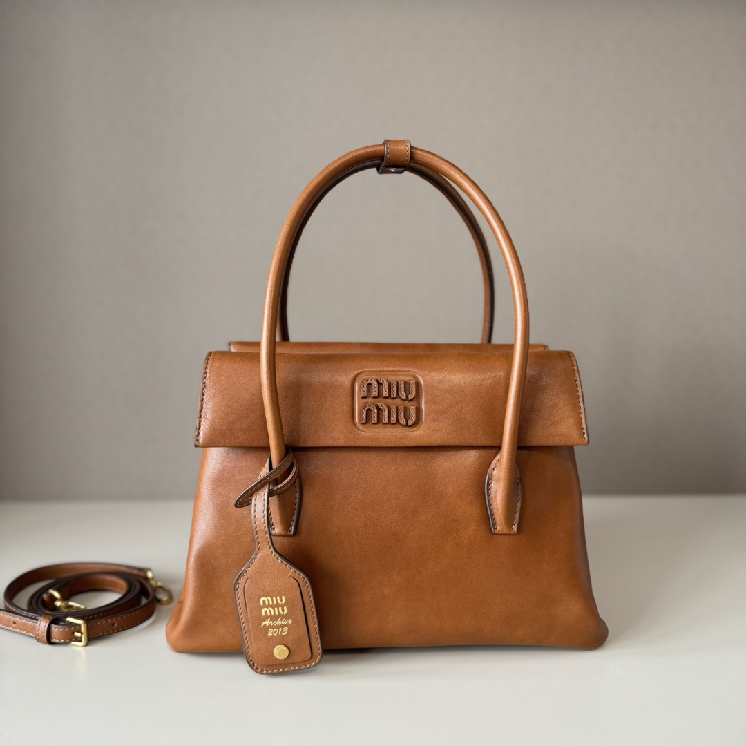 NO:340562,Super-grade original leather Miu Zhang Yuanying's same style, medieval handbag, exploring the diverse style of women, retro style, and quietly hiding a touch of playfulness, perfectly interpreting the combination of retro and fashionable, double-sided flip design, with a fashionable retro charm, and perfectly fits the warm atmosphere of the four seasons. It can not only add a sense of maturity and stability to the workplace outfit, but also easily integrate into casual daily life!  Large size 29 x 20 x 11cm Model: 5BA302 Gift box, large-scale MIUMIU, miumiu19860909特级 原厂皮 Miu 张元英同款秀款 中古手提包 探索女性多元风貌 复古风情 还悄悄藏着一丝俏皮感 完美演绎了复古又时尚的结合 双面翻盖设计 自带时髦的复古韵味 又完美契合四季温暖氛围 既能够为职场穿搭增加一份成熟稳重感 也能轻松融入休闲日常！ 大号尺寸29 x 20 x 11cm 型号:5BA302 配礼品盒,大厂货MIUMIU,miumiu,Bag