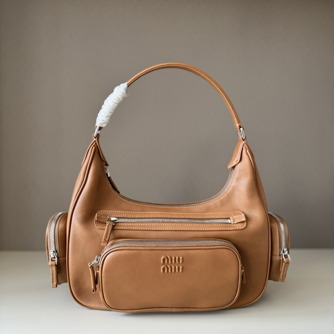 NO:617857,Big factory goods, original leather, new motorcycle bags. This Miu pocket bag is so versatile, it’s the one that’s sold out even if a rich family’s daughter is carrying it! Full leather inside and outside, the leather is very soft and feels super good. The Tori zipper + three-dimensional pockets are retro, and you can carry a bag under the arm to unlock 2 ways of carrying it. Fashionable girls, please plant this motorcycle bag! The size is 38cm long (including the 2 side pockets, 33cm without it). Model number 5BC189 caramel color. The size is 38cm long x 14cm wide x 20cm high. Made by a major manufacturer, MIUMIU, miumiu.19860909大厂货 原厂皮  新品机车包 这只miu的口袋包也太能装了吧,富家千金都在背的断貨王！里外全皮,皮质非常柔软 手感超级好 ,Tori拉链＋立体口袋复古拿捏了,可腋下可手提一包解锁2种背法,时髦精女孩们 请种草这款机车包吧！尺寸长38cm(包含侧边2个口袋一起量的,不包含是33cm) 款号5BC189焦糖色 尺寸长38×宽14×高20cm,大厂货MIUMIU,miumiu,Bag