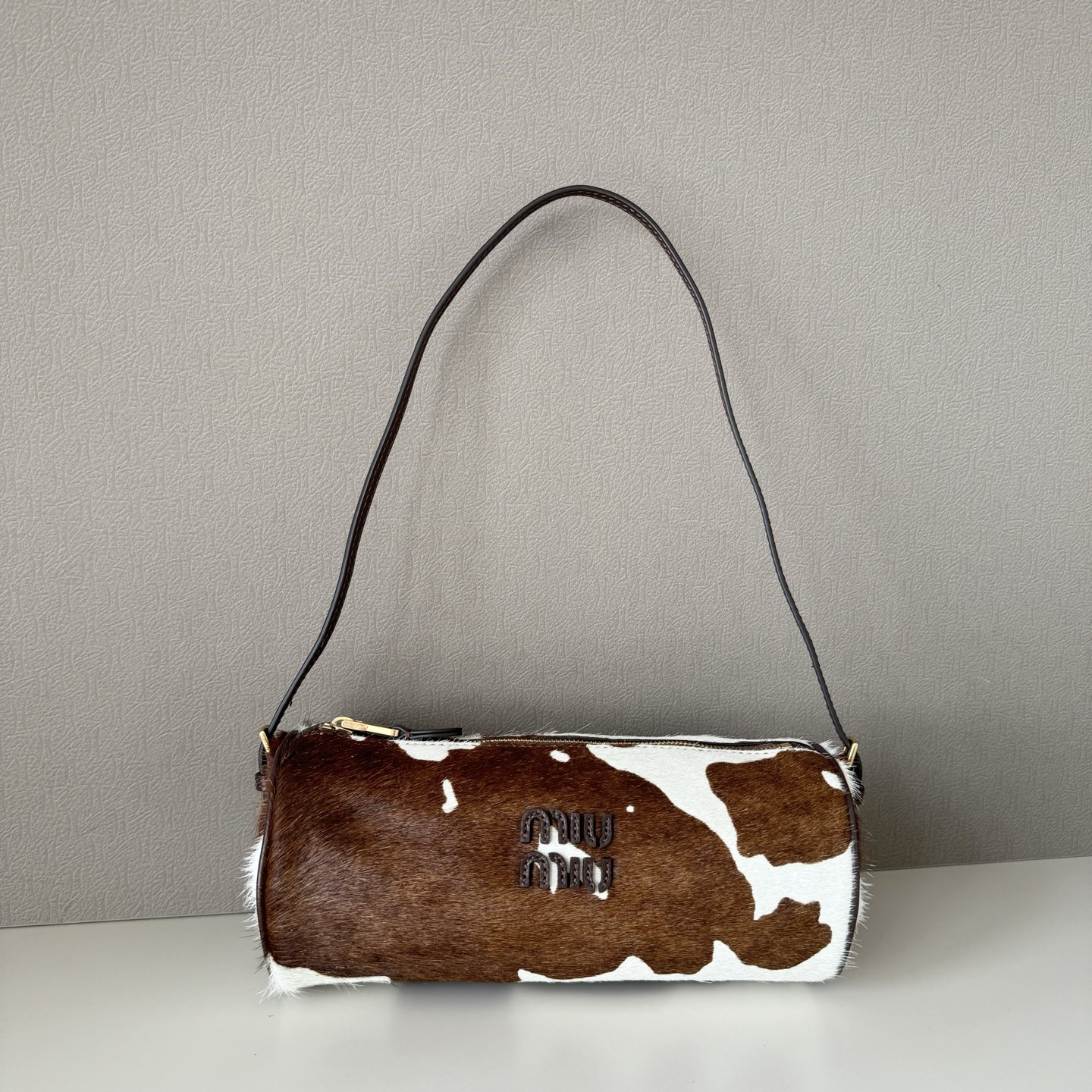 NO:687951,Big factory original leather cow small round pen holder bag, which perfectly combines retro wildness and girlish sweetness. The brown and white contrasting cow pattern fur material has its own eye-catching buff, and the round shape looks small, mini and exquisite, which is indeed a big deal. The capacity is very considerable, and it can easily hold three mobile phones. It can be carried on one shoulder and is super good-looking. Tips: It is soft and delicate, but it is inevitably prone to scratches. A good bag deserves to be cared for.  Model No. 5NE851 cow, size bottom length 22x width (diameter) 9.5x height 8.5cm, big factory product MIUMIU, miumiu19860909大厂货 原厂皮 奶牛小圆笔筒包,将复古野性与少女甜酷感揉合得恰到好处.棕白撞色的奶牛纹皮毛材质自带吸睛 buff,圆溜溜的外形看上去小巧迷你精致,确实大有乾坤,容量非常可观,轻轻松松装下三部手机,可手提单肩,超级好看.tips软糯细腻这是它的优点,但是不可避免容易产生划痕.好包包值得爱护 款号5NE851奶牛 尺寸底长22x宽（直径）9.5x 高8.5cm,大厂货MIUMIU,miumiu,Bag