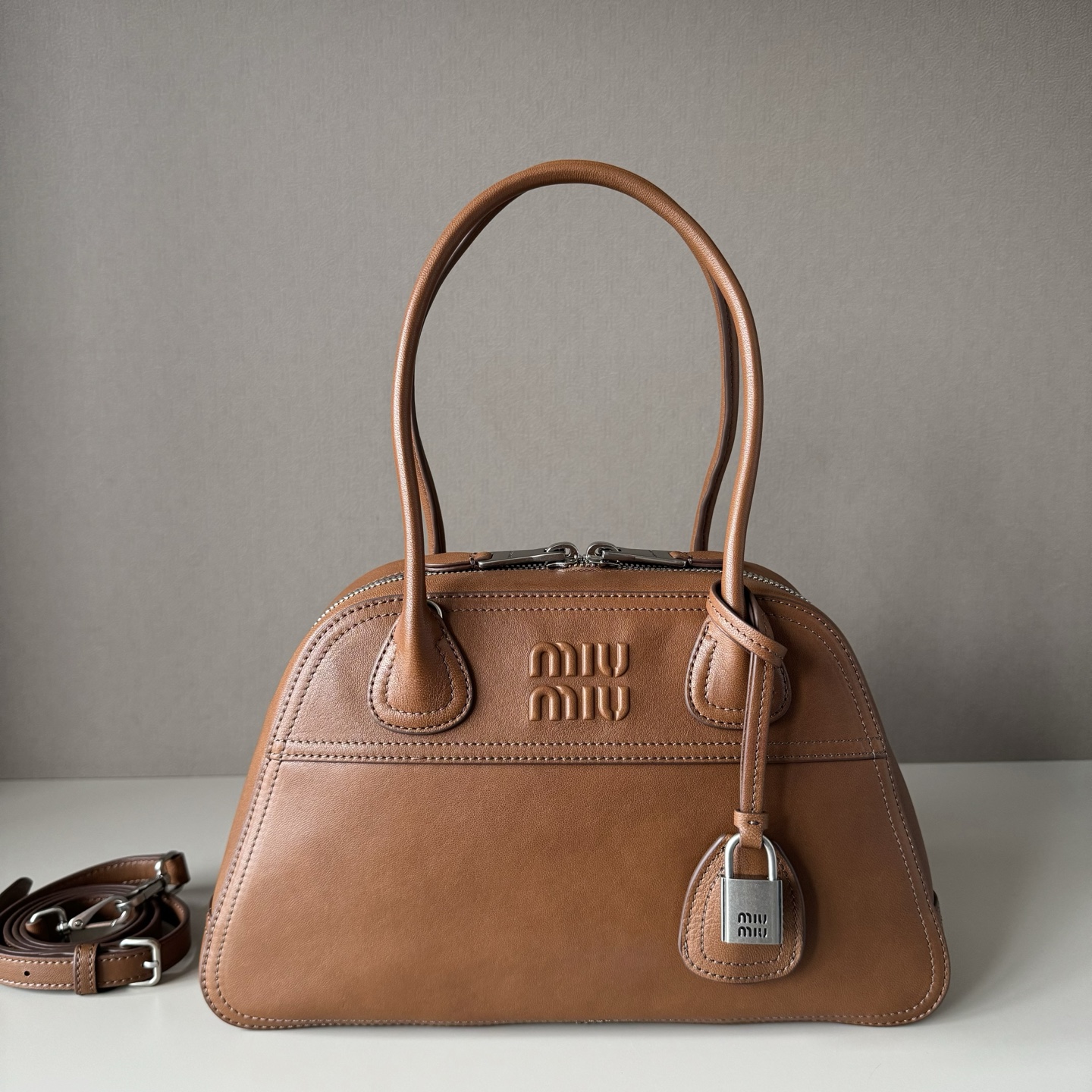NO:812537,Genuine leather, Miu's new hot-selling Vivant bowling bag in soft sheepskin brown, made of soft sheepskin, the leather is retro and high-grade, with a free and uninhibited sense of relaxation, exquisite outline, neat line details are perfectly reflected, decorated with embossed letter logo, adding iconic elements, retro distressed hardware accessories, linen blend lining, zipper pockets and patch pockets, long shoulder straps are more convenient to use hands-free, the wrist is suitable for handbags or shoulders, street dating, light commuting, exquisite party choice  Model: 5BB199 Size 32X19.5X11 cm, big factory products MIUMIU, miumiu, sheepskin19860909大厂货 原厂皮 Miu新品爆款Vivant保龄球包植柔羊皮棕色,采用做植柔羊皮,皮质复古高级,自带洒脱不羁的松驰感,精致轮廓,利落线条细节完美体现,饰以压花字母徽标,增添标志性元素,复古做旧五金配件,亚麻混纺衬里,配拉链口袋和贴袋,长肩带使用解放双手更便利,手腕适合用作手提或单肩,出街约会,轻通勤,精致党首选 型号:5BB199 尺寸32X19.5X11 cm,大厂货MIUMIU,miumiu,sheepskin,Bag