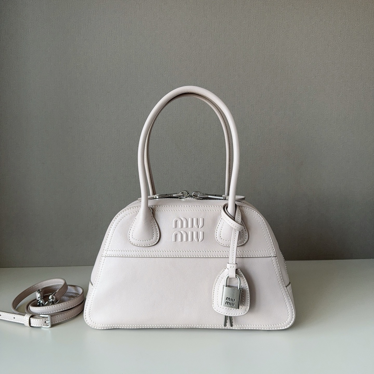 NO:812565,Big factory goods original leather  Miu's new hot-selling small Vivant bowling bag is in soft sheepskin. It is made of soft sheepskin. The leather is retro and high-grade. It has a free and uninhibited sense of relaxation. It has a refined outline and neat line details. It is decorated with an embossed letter logo to add iconic elements. It has retro distressed hardware and a linen blend lining. It is equipped with zipper pockets and patch pockets. The long shoulder strap is more convenient to use to free your hands. The wrist is suitable for use as a handbag or a shoulder. It is suitable for street dates, light commuting, and is the first choice for exquisite parties. Model: 5BB  Size: 28 x 17 x 9.5cm, big factory products MIUMIU, miumiu, sheepskin19860909大厂货  原厂皮 Miu新品爆款小号Vivant保龄球包植柔羊皮白色,采用做植柔羊皮,皮质复古高级,自带洒脱不羁的松驰感,精致轮廓,利落线条细节完美体现,饰以压花字母徽标,增添标志性元素,复古做旧五金配件,亚麻混纺衬里,配拉链口袋和贴袋,长肩带使用解放双手更便利,手腕适合用作手提或单肩,出街约会,轻通勤,精致党首选 型号:5BB 尺寸:28 x 17 x 9.5cm,大厂货MIUMIU,miumiu,sheepskin,Bag
