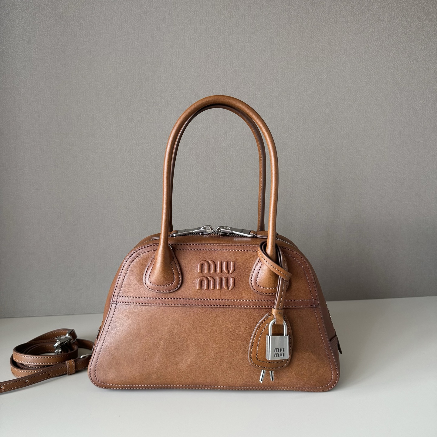 NO:812567,Big factory leather original Miu new popular small Vivant bowling bag brown, made of soft sheepskin, retro and high-grade leather, with a free and uninhibited sense of relaxation, exquisite outline, neat line details perfectly reflected, decorated with embossed letter logo, adding iconic elements, retro distressed hardware accessories, linen blend lining, with zipper pockets and patch pockets, long shoulder straps are more convenient to use hands-free, the wrist is suitable for handbags or shoulders, street dating, light commuting, exquisite party choice  Model: 5BB Size: 28 x 17 x 9.5cm, big factory products MIUMIU, miumiu, sheepskin19860909大厂货 原厂皮 Miu新品爆款小号Vivant保龄球包棕色,采用做植柔羊皮,皮质复古高级,自带洒脱不羁的松驰感,精致轮廓,利落线条细节完美体现,饰以压花字母徽标,增添标志性元素,复古做旧五金配件,亚麻混纺衬里,配拉链口袋和贴袋,长肩带使用解放双手更便利,手腕适合用作手提或单肩,出街约会,轻通勤,精致党首选 型号:5BB 尺寸:28 x 17 x 9.5cm,大厂货MIUMIU,miumiu,sheepskin,Bag
