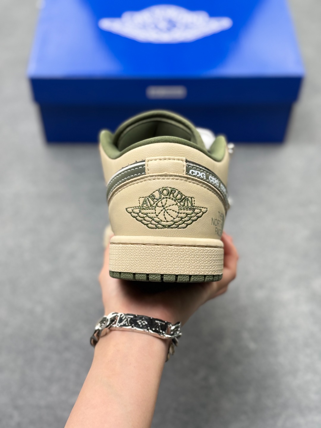 💰240
Air Jordan 1 Low x 北面 x CDG 联名款｜野性与潮流的碰撞。当飞人图腾邂逅户外传奇，再融合先锋时尚的基因，这双Air Jordan 1 Low QG1988-017直接把跨界联名的质感拉满！浅卡其色鞋身搭配墨绿迷彩拼接，皮革与耐磨材质的碰撞，既有AJ1经典的复古轮廓，又注入了The North Face的户外硬核气质。鞋侧Swoosh满印CDG标识，后跟北面logo醒目点缀，三重品牌元素的融合毫不违和，每一处细节都透着潮流与机能的双重魅力。粗织鞋带、撞色包边的设计，让这双鞋不仅是穿搭利器，更暗藏户外探索的野性；低帮版型兼顾日常上脚的舒适与百搭，不管是街头潮搭还是轻户外造型，都能轻松hold住。这双集AJ的经典、北面的硬核、CDG的先锋于一体的联名款，是潮流玩家和户外爱好者都无法拒绝的收藏级单品！