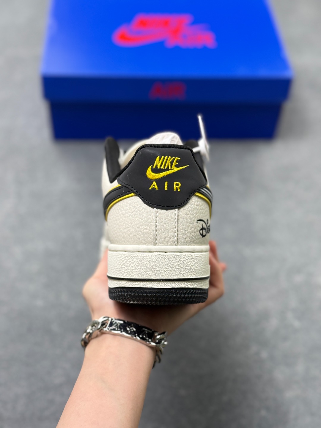 💰220
童趣奢潮碰撞！AF1 Low x Disney 联名款唤醒童年DNA
 当Nike Air Force 1 Low的经典街头骨架遇上迪士尼的童话基因，这双SY1388-021联名款直接把「潮玩童趣」焊在了鞋面上！
 鞋身以奶白荔枝纹皮革搭配浅灰磨砂皮打造基底，黑黄撞色的Swoosh线条利落又俏皮，黄色包边如漫画描边般勾勒出灵动质感。鞋头的米奇轮廓简笔画、鞋侧的Disney手写体标识，将迪士尼的经典元素以手绘风呈现，细节处满是童真巧思；黑白撞色鞋带搭配经典AF1中底的「AIR」标识，保留了空军一号的街头底蕴，让童趣与潮流实现完美平衡。
 作为AF1与迪士尼的跨界联名，这双鞋既延续了Air Force 1 Low的百搭属性，又凭借迪士尼的IP加持成为吸睛利器。不管是日常出街打造甜酷造型，还是作为迪士尼粉丝的收藏款，这双AF1 Low x Disney联名款都能让你在潮流圈玩转出独特的童趣风格，属于大人的童话潮鞋，入手即解锁双倍快乐！
size：36-45半 X3
