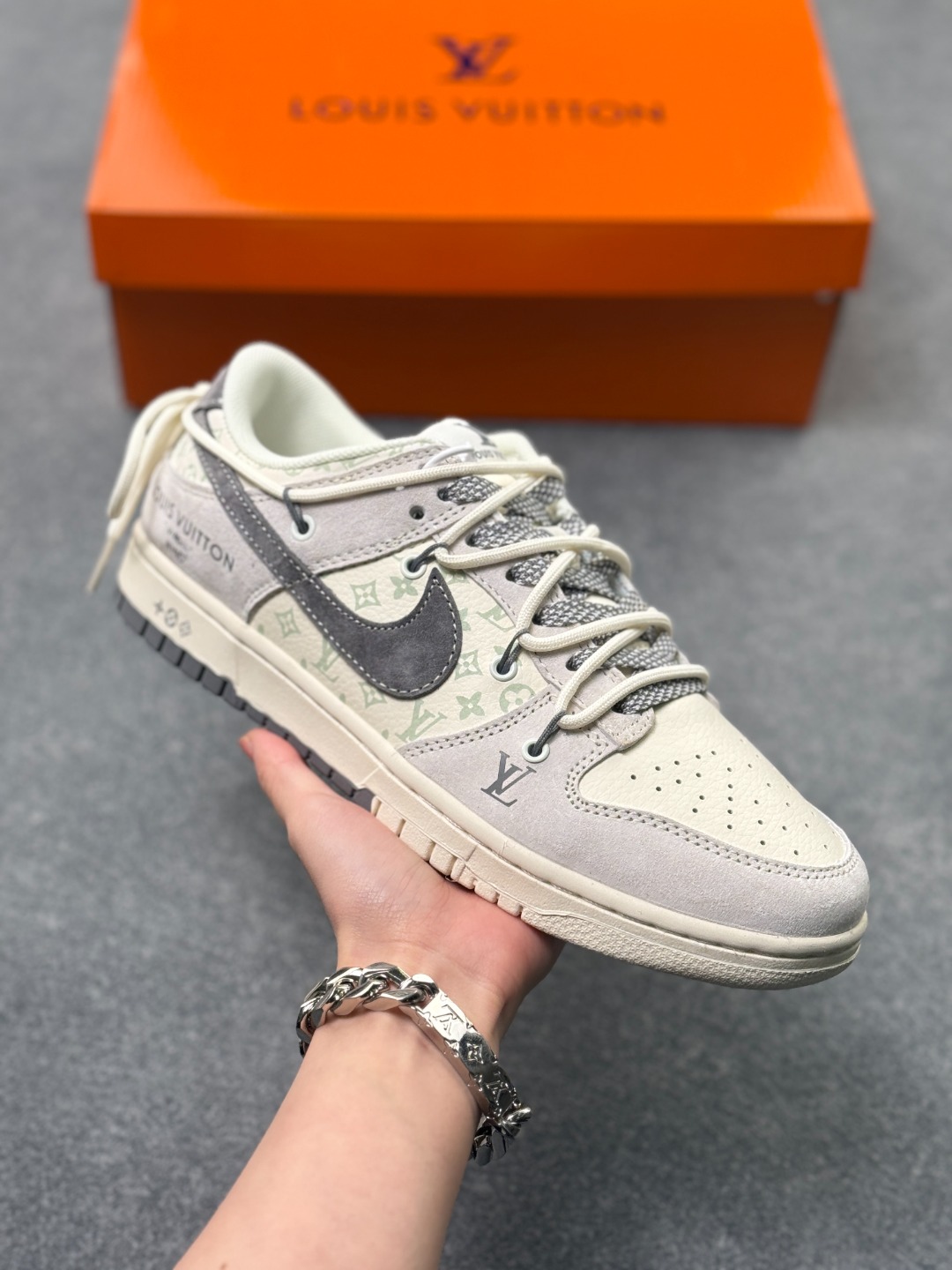 💰250
Nike Dunk Low x LV 联名款|雾霾灰调的奢潮新标杆
这双Nike Dunk Low CX5050-Y45与LV的联名鞋款,堪称街头潮流与高端奢品融合的典范之作,从材质选择到细节设计,都将奢潮美学展现得淋漓尽致。
鞋面以雾霾灰麂皮为基底,搭配浅灰调的LV经典老花印花皮革拼接,低饱和的灰系配色营造出清冷高级的视觉氛围,麂皮的细腻绒面与印花皮革的精致纹理形成鲜明质感对比,触手可及的高端材质,让每一次上脚都能感受到奢品工艺的魅力。鞋身侧方的Nike Swoosh采用深灰磨砂皮质打造,与LV字母标识、老花图案相互呼应,鞋舌与鞋跟处的细节标识更是将联名身份拉满,每一处设计都暗藏巧思。延续Dunk Low的经典鞋型架构,鞋身线条流畅利落,中底采用轻量发泡材质打造,兼顾了复古造型与脚感舒适度,橡胶外底的人字形纹路提供了出色的防滑耐磨性。无论是搭配街头风的工装裤、休闲牛仔,还是简约的运动套装,这双鞋都能轻松成为造型的视觉焦点,是潮人鞋柜中极具收藏价值的奢潮单品,更是彰显个性与品味的不二之选。尺码:36 36.5 37.5 38 38.5 39 40 40.5 41 42 42.5 43 44 44.5 45 x71