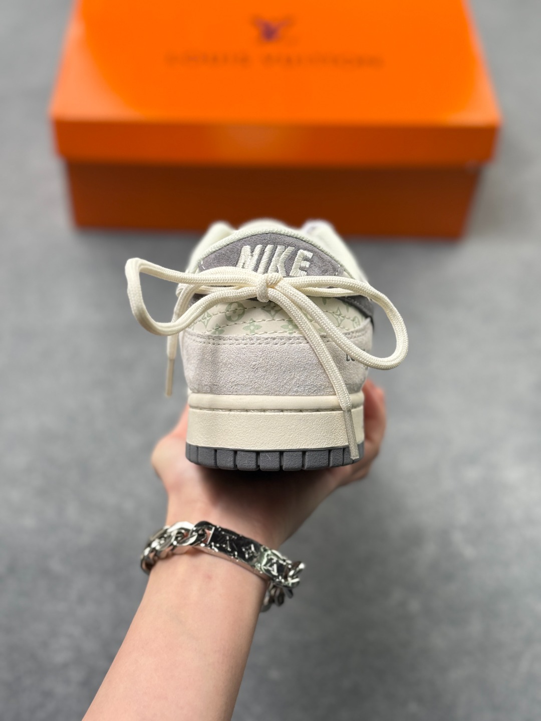 💰250
Nike Dunk Low x LV 联名款|雾霾灰调的奢潮新标杆
这双Nike Dunk Low CX5050-Y45与LV的联名鞋款,堪称街头潮流与高端奢品融合的典范之作,从材质选择到细节设计,都将奢潮美学展现得淋漓尽致。
鞋面以雾霾灰麂皮为基底,搭配浅灰调的LV经典老花印花皮革拼接,低饱和的灰系配色营造出清冷高级的视觉氛围,麂皮的细腻绒面与印花皮革的精致纹理形成鲜明质感对比,触手可及的高端材质,让每一次上脚都能感受到奢品工艺的魅力。鞋身侧方的Nike Swoosh采用深灰磨砂皮质打造,与LV字母标识、老花图案相互呼应,鞋舌与鞋跟处的细节标识更是将联名身份拉满,每一处设计都暗藏巧思。延续Dunk Low的经典鞋型架构,鞋身线条流畅利落,中底采用轻量发泡材质打造,兼顾了复古造型与脚感舒适度,橡胶外底的人字形纹路提供了出色的防滑耐磨性。无论是搭配街头风的工装裤、休闲牛仔,还是简约的运动套装,这双鞋都能轻松成为造型的视觉焦点,是潮人鞋柜中极具收藏价值的奢潮单品,更是彰显个性与品味的不二之选。尺码:36 36.5 37.5 38 38.5 39 40 40.5 41 42 42.5 43 44 44.5 45 x71
