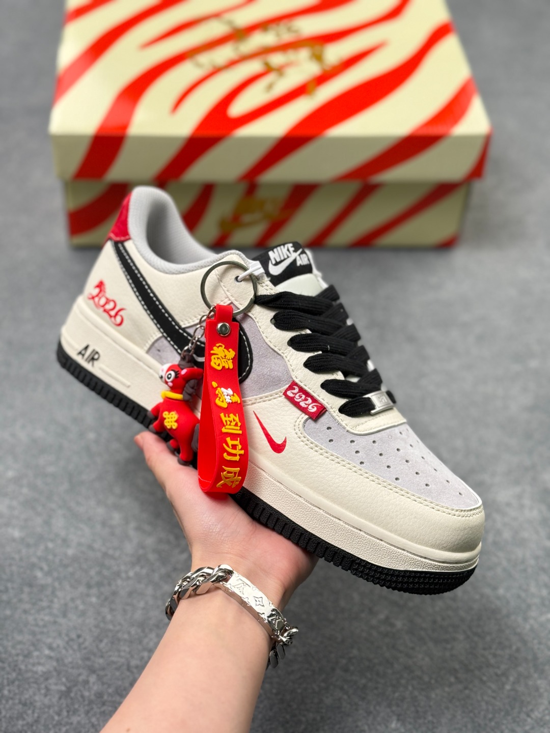 马年限定海外爆款限量发售!高端定制Nike Air Force 1 '07 Low “马年限定-马踏祥云白灰” 高端定制,米白 + 浅灰撞色清爽又高级,红黑勾子嵌祥云纹,鞋侧「2026」红标 + 小马挂坠,鞋面用头层牛皮 + 麂皮拼接,质感细腻耐造;勾子处是立体刺绣 + 压纹工艺,祥云纹路精致不廉价 低帮休闲板鞋 定制鞋盒 大厂纯原品质出货 超高清洁度 皮料切割干净无任何毛边 细节完美 货号:XD0028-015 x52