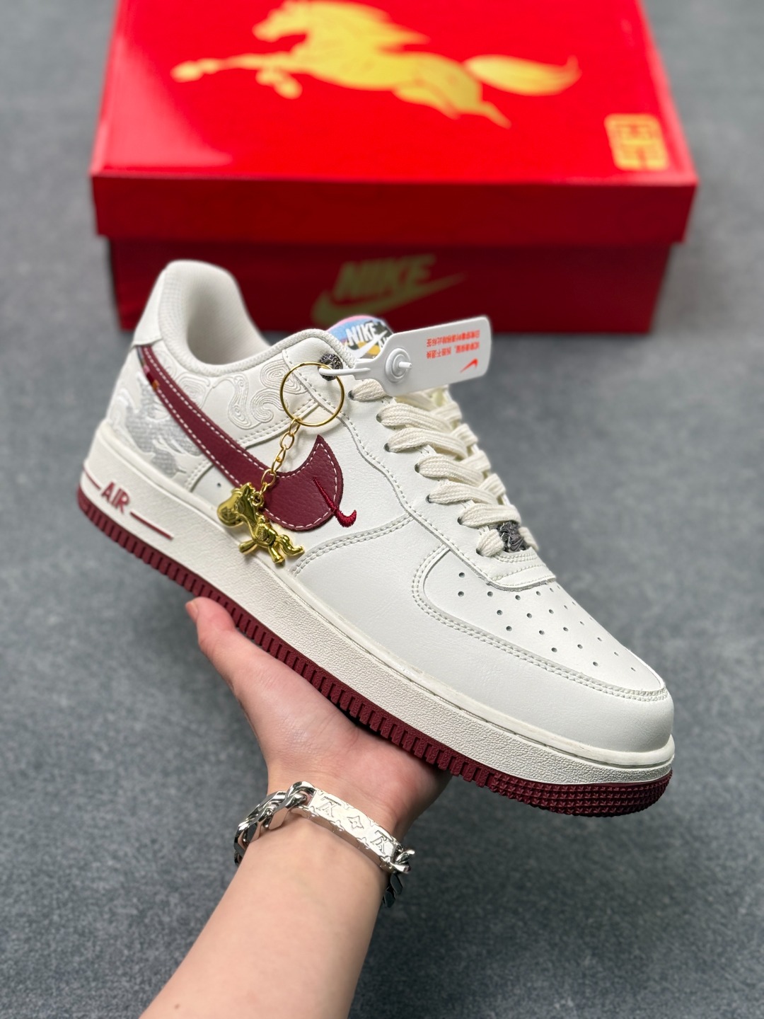 🐎Nike Air Force 1 马年限定款美到犯规!白红主调搭配祥云暗纹,酒红Swoosh与金色小马挂饰呼应2026马年主题,细节藏满国风巧思.经典AF1低帮鞋型搭载Air气垫中底,脚感软糯又稳脚,专属编码款稀缺度拉满,新年上脚既具年味仪式感,又能轻松拿捏街头潮范! 货号:DD1982-348 x56