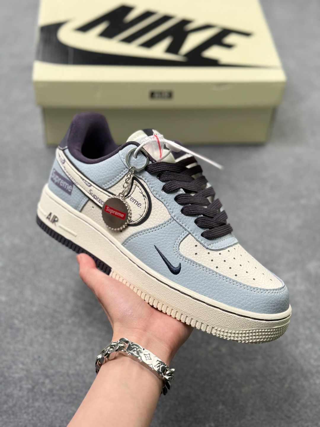 💰220
蓝调解构，街头顶流！ 当Nike Air Force 1 Low的经典轮廓遇上Supreme的街头基因，这双DD1928-308直接把潮流氛围感拉满💙！雾霾蓝为主调的鞋身，拼接米白皮质打造出解构美学，鞋侧的Supreme标识与Nike Swoosh交错呼应，细节处的金属挂饰更是点睛之笔，复古做旧的中底刻着AIR字样，瞬间拉满复古街头那味儿～
 不管是搭配工装裤还是牛仔套装，这双鞋都能成为造型的视觉核心，既是AF1的经典延续，也是Supreme联名的潮流硬通货，街头玩家的鞋柜里怎么能少了这一抹蓝调惊
size：36-45半 x3