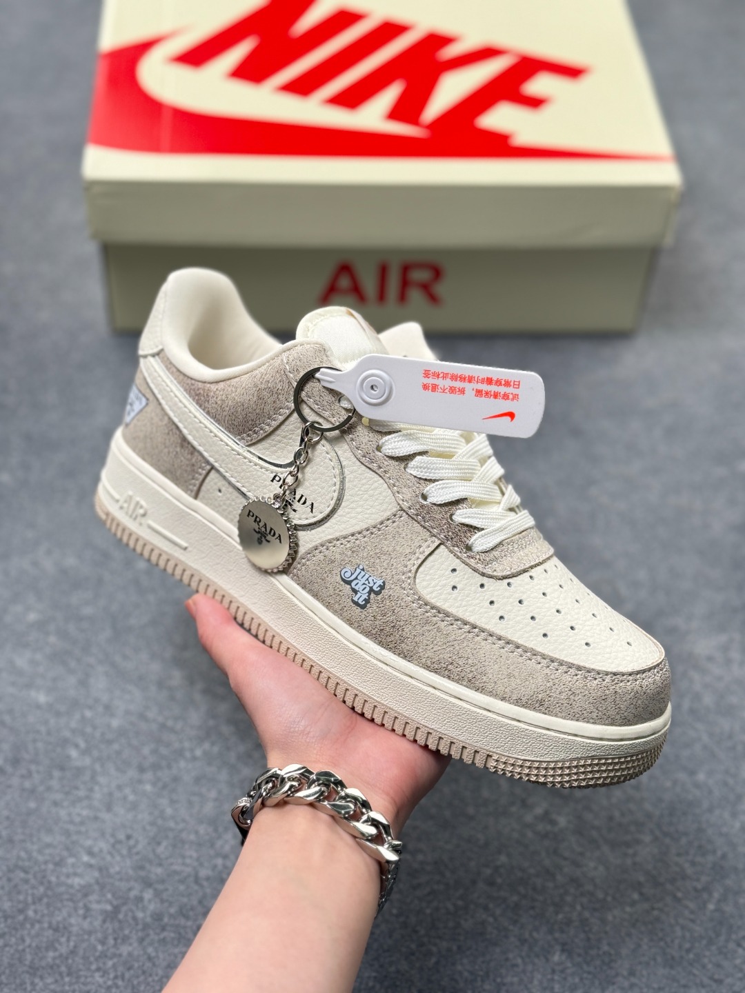 💰220
Nike Air Force 1 Low x PRADA 联名款｜奶油灰调的奢雅新风尚！这双Nike Air Force 1 Low XL1979-129与PRADA的联名鞋款，将高端奢品的精致美学与街头经典鞋型完美融合，成为潮奢跨界的又一标杆之作。鞋面选用细腻的奶油灰麂皮与米白色皮革拼接打造，柔和的低饱和色调自带高级质感，触手可及的细腻绒面纹理，让材质的高级感在细节处拉满。鞋身侧方的Nike Swoosh标志融入PRADA经典三角标与品牌字母标识，鞋头处的“Just Do It”字样以精致刺绣呈现，奢牌元素与运动基因的碰撞，让每一处设计都充满辨识度。延续Air Force 1的经典中底设计，内嵌Air气垫科技，带来柔软回弹的上脚体验，橡胶外底的防滑纹路经过优化，兼顾日常穿着的舒适度与实用性。无论是搭配简约的通勤装，还是休闲的潮牌穿搭，这双鞋都能以低调奢雅的风格提升整体造型质感，是追求品质与个性的鞋迷不容错过的收藏级单品。 
size:36-45半 x3