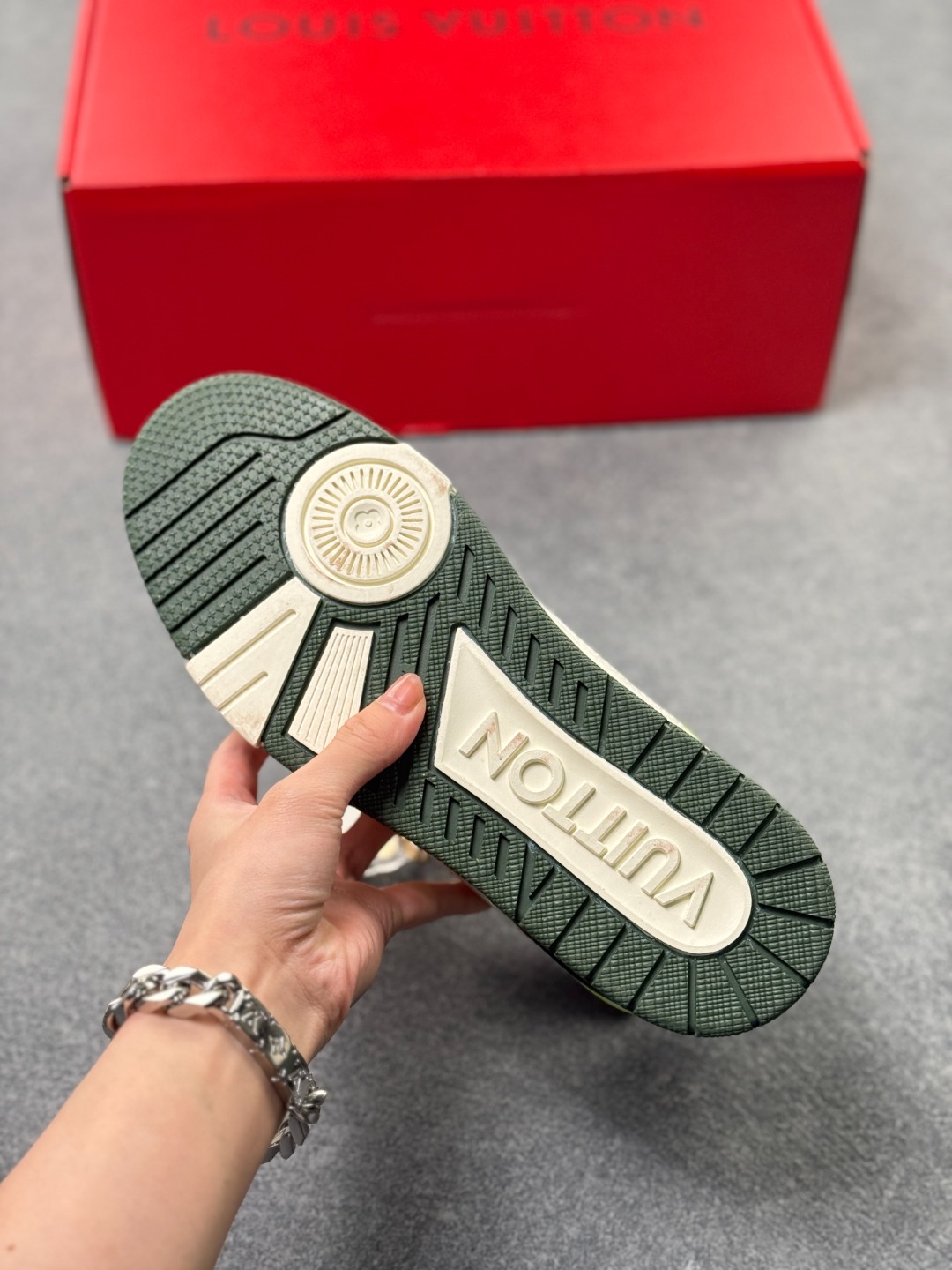 LV TRAINER白灰+荧光绿(中国红限定礼盒版本-钥匙扣丢失扣20元) 26年限定中国红礼盒及全套包装说明书防尘布袋物件,完美楦型,独家开模定制! trainer这个系列是路易威登融合街头潮流与高级时装的标志性之作.在材料选用上,鞋面采用Monogram印花与Monogram压纹粒面牛皮革的搭配,呈现出独特的复古韵味.荔枝纹粒面头层牛革鞋面,触感细腻且富有韧性,自带自然的皮革纹理,彰显高级质感,为鞋子增添了丰富的层次感.鞋垫采用原版超软乳胶材质,新鞋零磨合不磨脚,软乎乎的皮质包裹感超棒,鞋底则采用橡胶材质,刻有经典的Monogram花卉纹路,不仅防滑,还带走缓震效果还极具设计感.做工方面,TRAINER系列板鞋展现了精湛的工艺水准.鞋头采用圆润设计,原版空胶工艺搭配包边工艺,不仅美观,还能有效防踢蹭.鞋舌、侧面和后部饰有LV字母,侧面还有Vuitton标识,均做工精细,彰显品牌身份.鞋身走线工整均匀,看不到任何多余的线头,皮革的拼接处也处理得极为细腻,体现了我们对细节的极致追求.百搭属性直接封神!配牛仔裤是复古街头风,搭西装裤秒变松弛通勤感,甚至配半身裙都甜妹感拉满,堪称"衣柜万能钥匙".这双集颜值、质感、实穿性于一体的奢牌板鞋! 货号:2A8DM18VL IZE:36 37 38 39 40 41 42 43 44 45(不带半)x45