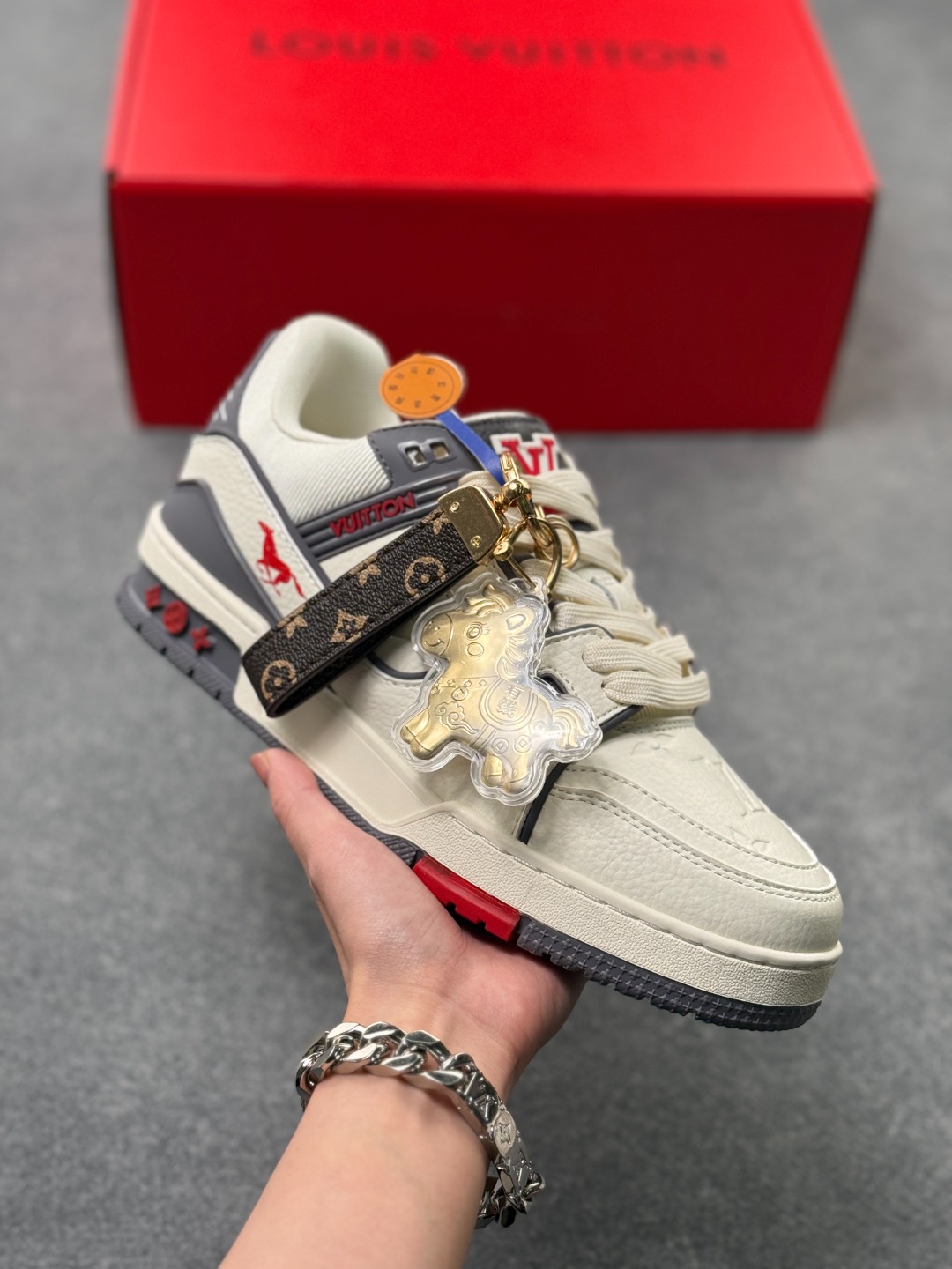 LV TRAINER白深灰(中国红限定礼盒版本) 26年限定中国红礼盒及全套包装说明书防尘布袋物件,完美楦型,独家开模定制! trainer这个系列是路易威登融合街头潮流与高级时装的标志性之作.在材料选用上,鞋面采用Monogram印花与Monogram压纹粒面牛皮革的搭配,呈现出独特的复古韵味.荔枝纹粒面头层牛革鞋面,触感细腻且富有韧性,自带自然的皮革纹理,彰显高级质感,为鞋子增添了丰富的层次感.鞋垫采用原版超软乳胶材质,新鞋零磨合不磨脚,软乎乎的皮质包裹感超棒,鞋底则采用橡胶材质,刻有经典的Monogram花卉纹路,不仅防滑,还带走缓震效果还极具设计感.做工方面,TRAINER系列板鞋展现了精湛的工艺水准.鞋头采用圆润设计,原版空胶工艺搭配包边工艺,不仅美观,还能有效防踢蹭.鞋舌、侧面和后部饰有LV字母,侧面还有Vuitton标识,均做工精细,彰显品牌身份.鞋身走线工整均匀,看不到任何多余的线头,皮革的拼接处也处理得极为细腻,体现了我们对细节的极致追求.百搭属性直接封神!配牛仔裤是复古街头风,搭西装裤秒变松弛通勤感,甚至配半身裙都甜妹感拉满,堪称"衣柜万能钥匙".这双集颜值、质感、实穿性于一体的奢牌板鞋! 货号:2A8DM20VL IZE:36 37 38 39 40 41 42 43 44 45(不带半)x45