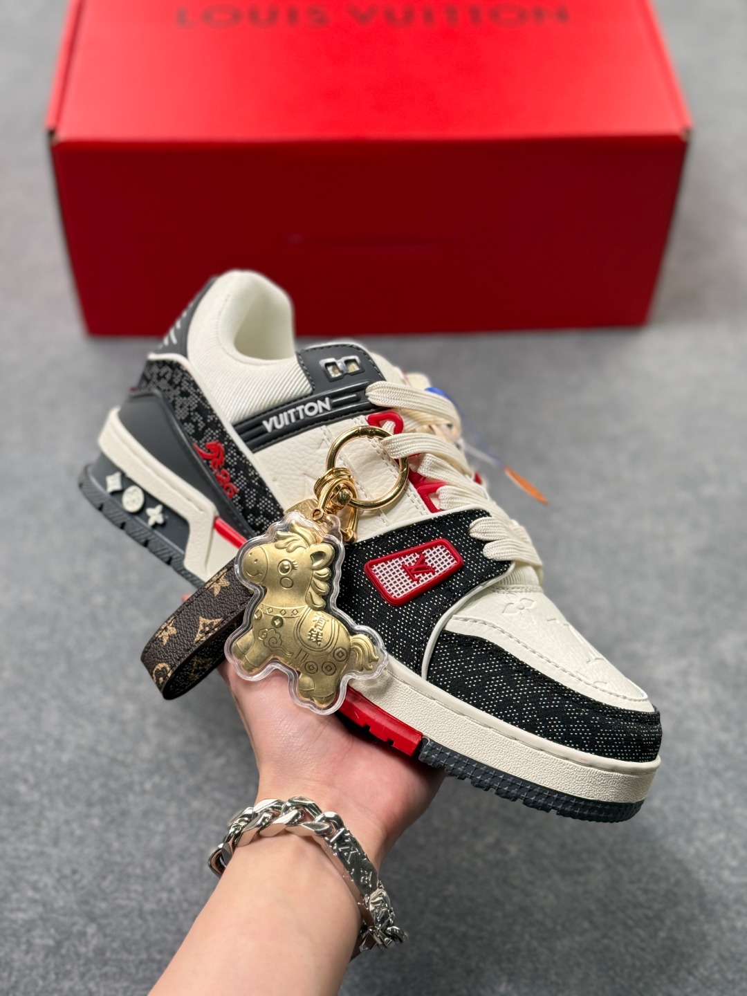 LV TRAINER黑格纹(中国红限定礼盒版本-钥匙扣丢失扣20元) 26年限定中国红礼盒及全套包装说明书防尘布袋物件,完美楦型,独家开模定制! trainer这个系列是路易威登融合街头潮流与高级时装的标志性之作.在材料选用上,鞋面采用Monogram印花与Monogram压纹粒面牛皮革的搭配,呈现出独特的复古韵味.荔枝纹粒面头层牛革鞋面,触感细腻且富有韧性,自带自然的皮革纹理,彰显高级质感,为鞋子增添了丰富的层次感.鞋垫采用原版超软乳胶材质,新鞋零磨合不磨脚,软乎乎的皮质包裹感超棒,鞋底则采用橡胶材质,刻有经典的Monogram花卉纹路,不仅防滑,还带走缓震效果还极具设计感.做工方面,TRAINER系列板鞋展现了精湛的工艺水准.鞋头采用圆润设计,原版空胶工艺搭配包边工艺,不仅美观,还能有效防踢蹭.鞋舌、侧面和后部饰有LV字母,侧面还有Vuitton标识,均做工精细,彰显品牌身份.鞋身走线工整均匀,看不到任何多余的线头,皮革的拼接处也处理得极为细腻,体现了我们对细节的极致追求.百搭属性直接封神!配牛仔裤是复古街头风,搭西装裤秒变松弛通勤感,甚至配半身裙都甜妹感拉满,堪称"衣柜万能钥匙".这双集颜值、质感、实穿性于一体的奢牌板鞋! 货号:2A8DM28VL IZE:36 37 38 39 40 41 42 43 44 45(不带半)x45