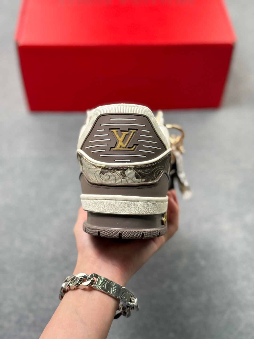 LV TRAINER迷彩马纹(中国红限定礼盒版本-钥匙扣丢失扣20元) 26年限定中国红礼盒及全套包装说明书防尘布袋物件,完美楦型,独家开模定制! trainer这个系列是路易威登融合街头潮流与高级时装的标志性之作.在材料选用上,鞋面采用Monogram印花与Monogram压纹粒面牛皮革的搭配,呈现出独特的复古韵味.荔枝纹粒面头层牛革鞋面,触感细腻且富有韧性,自带自然的皮革纹理,彰显高级质感,为鞋子增添了丰富的层次感.鞋垫采用原版超软乳胶材质,新鞋零磨合不磨脚,软乎乎的皮质包裹感超棒,鞋底则采用橡胶材质,刻有经典的Monogram花卉纹路,不仅防滑,还带走缓震效果还极具设计感.做工方面,TRAINER系列板鞋展现了精湛的工艺水准.鞋头采用圆润设计,原版空胶工艺搭配包边工艺,不仅美观,还能有效防踢蹭.鞋舌、侧面和后部饰有LV字母,侧面还有Vuitton标识,均做工精细,彰显品牌身份.鞋身走线工整均匀,看不到任何多余的线头,皮革的拼接处也处理得极为细腻,体现了我们对细节的极致追求.百搭属性直接封神!配牛仔裤是复古街头风,搭西装裤秒变松弛通勤感,甚至配半身裙都甜妹感拉满,堪称"衣柜万能钥匙".这双集颜值、质感、实穿性于一体的奢牌板鞋! 货号:2A8DM21VL IZE:36 37 38 39 40 41 42 43 44 45(不带半)x45