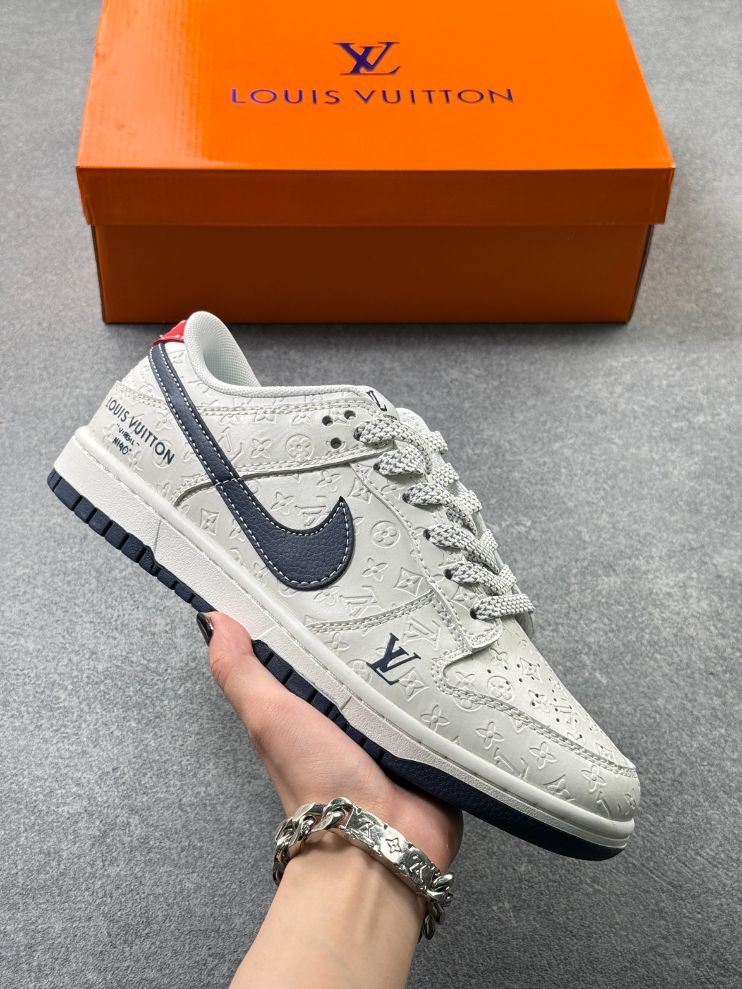 轻奢联名 潮力拉满 SB DUNK LOW,DUNK低帮经典鞋型融合LV轻奢元素,满印压纹皮革质感高级,藏青Swoosh搭配金属挂饰细节精致,米白底色干净清爽,脚感扎实舒适,兼具颜值与实用性,街头穿搭氛围感直接拉满,是个性玩家的必入潮鞋. 货号:XX3168-146 x69