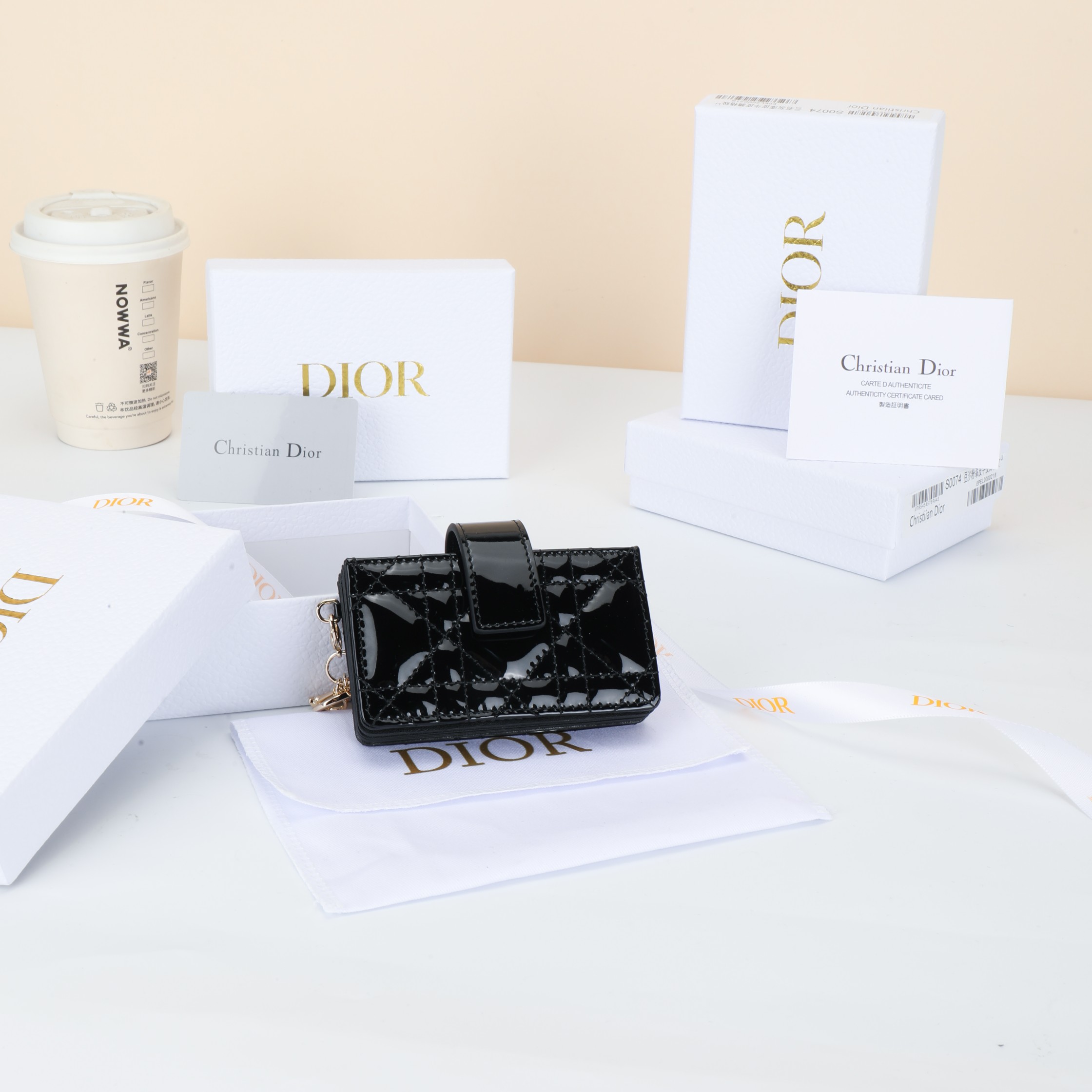 NO:852875,Number: S00740VRB_M51U Size 10.4×7×2cm This Lady Dior Jasmine card holder is decorated with classic cannage pattern topstitching, paying tribute to the exquisite craftsmanship of Dior leather craftsmen. It is carefully made of black patent cow leather, sophisticated and practical, and can store a variety of daily necessities. Decorated with triangle gusset, with removable D.I.O.R. charm and strap snap closure, can be combined with other Lady Dior  Match Dior items to create matching looks.,Dior wallet,dior,wallets,cowhide19860909编号:S00740VRB_M51U 尺寸10.4×7×2cm 这款 Lady Dior Jasmine 卡夹饰有经典的藤格纹缉面线,向 Dior皮 革工匠的精湛工艺致敬.采黑色漆皮牛皮革精心制作,精 实用,可收纳各种日常用品.饰以三角形衬料,搭配可拆卸 D.I.O.R.吊饰和饰带按扣开合,可与其他 Lady Dior单品搭配,打 造配套造型.,Dior钱包,dior,wallets,cowhide,欧美剧