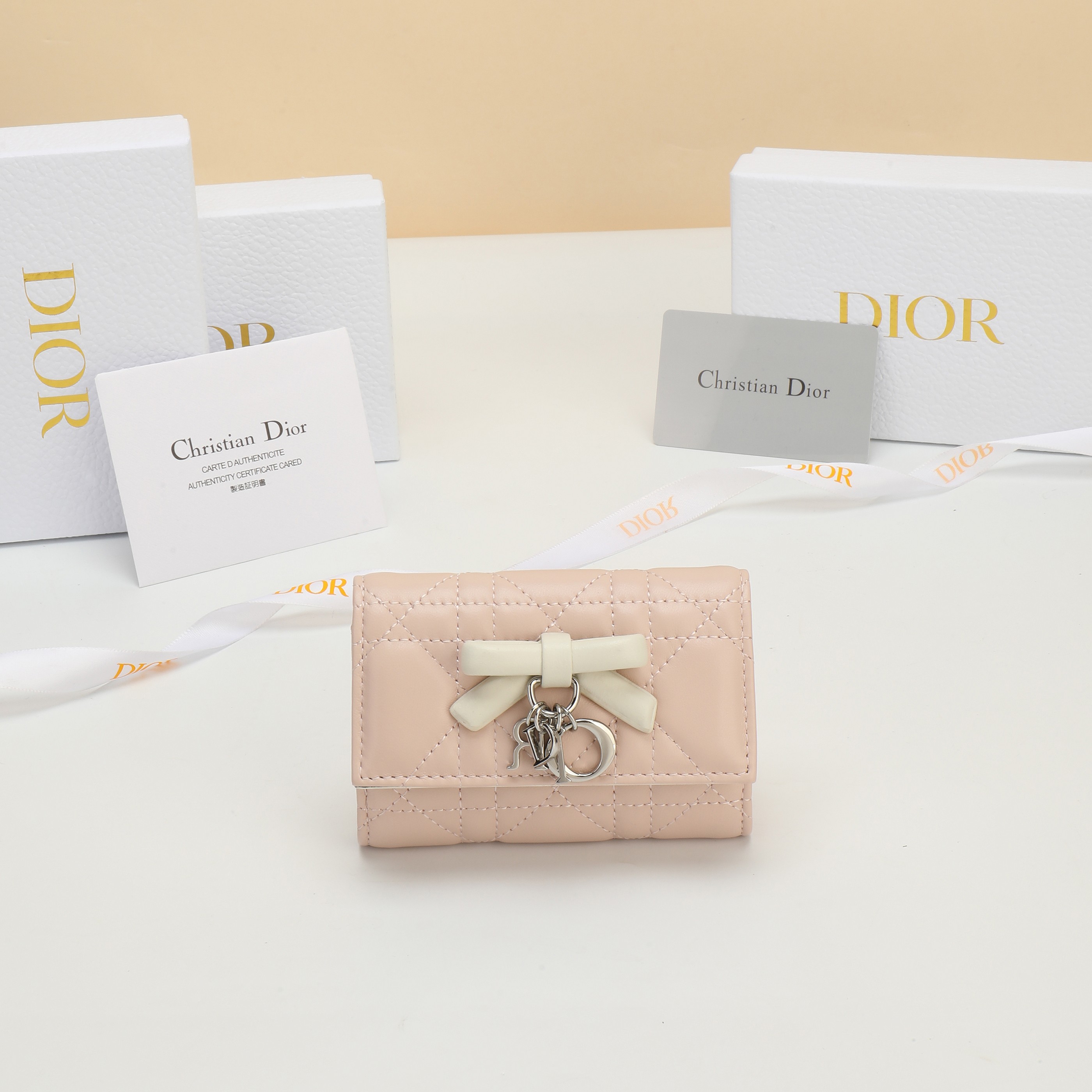 NO:813188,No. S2607OUQA_M900_TU Dimensions 11×7.5×3cm This Lady Dior Glycine wallet is compact and practical, but unique. It is pink and creamy white in two-tone style, carefully made of sheep leather, decorated with cannage pattern topstitching, and decorated with a decorative leather bow on the front to enhance the style, embellished with D.I.O.R. charms. Elegant and refined, it can store various daily necessities, suitable for various occasions, and can be combined with other Lady Dior wallets.  Dior single product matching., Dior wallet, dior, wallets, sheepskin19860909编号S2607OUQA_M900_TU 尺寸11×7.5×3cm 这款 Lady Dior Glycine钱包精巧实用,别具一格.粉色和奶白色 双色款式,采用羊皮革精心制作,饰以藤格纹缉面线,正面饰以装 饰性皮革蝴蝶结提升格调,点缀以D.I.O.R.吊饰.高雅精致,可收 纳各种日常用品,适合各种场合,可与其他 Lady Dior单品搭配.,Dior钱包,dior,wallets,sheepskin,Wallet purse