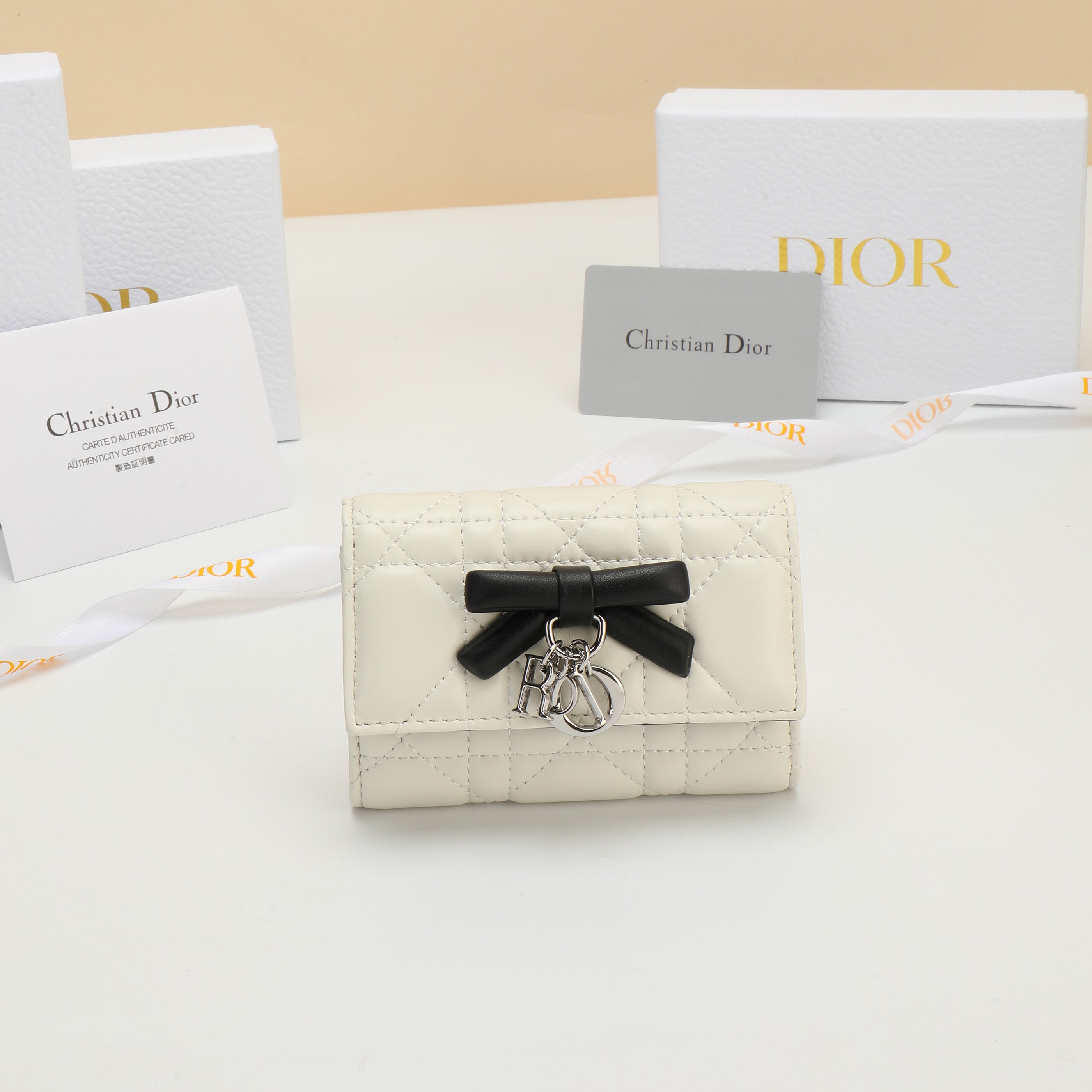 NO:813197,No. S2607OUQA_M900_TU Dimensions 11×7.5×3cm This Lady Dior Glycine wallet is compact and practical, but unique. The two-tone style of cream white and black is carefully made of sheep leather, decorated with cannage pattern topstitching. The front is decorated with a decorative leather bow to enhance the style, and is embellished with D.I.O.R. charms. Elegant and refined, it can store various daily necessities, suitable for various occasions, and can be combined with other Lady Dior wallets.  Dior single product matching., Dior wallet, dior, wallets, sheepskin19860909编号S2607OUQA_M900_TU 尺寸11×7.5×3cm 这款 Lady Dior Glycine 钱包精巧实用,别具一格.奶白色和黑色 双色款式,采用羊皮革精心制作,饰以藤格纹缉面线,正面饰以装 饰性皮革蝴蝶结提升格调,点缀以 D.I.O.R.吊饰.高雅精致,可收 纳各种日常用品,适合各种场合,可与其他 Lady Dior单品搭配.,Dior钱包,dior,wallets,sheepskin,Wallet purse