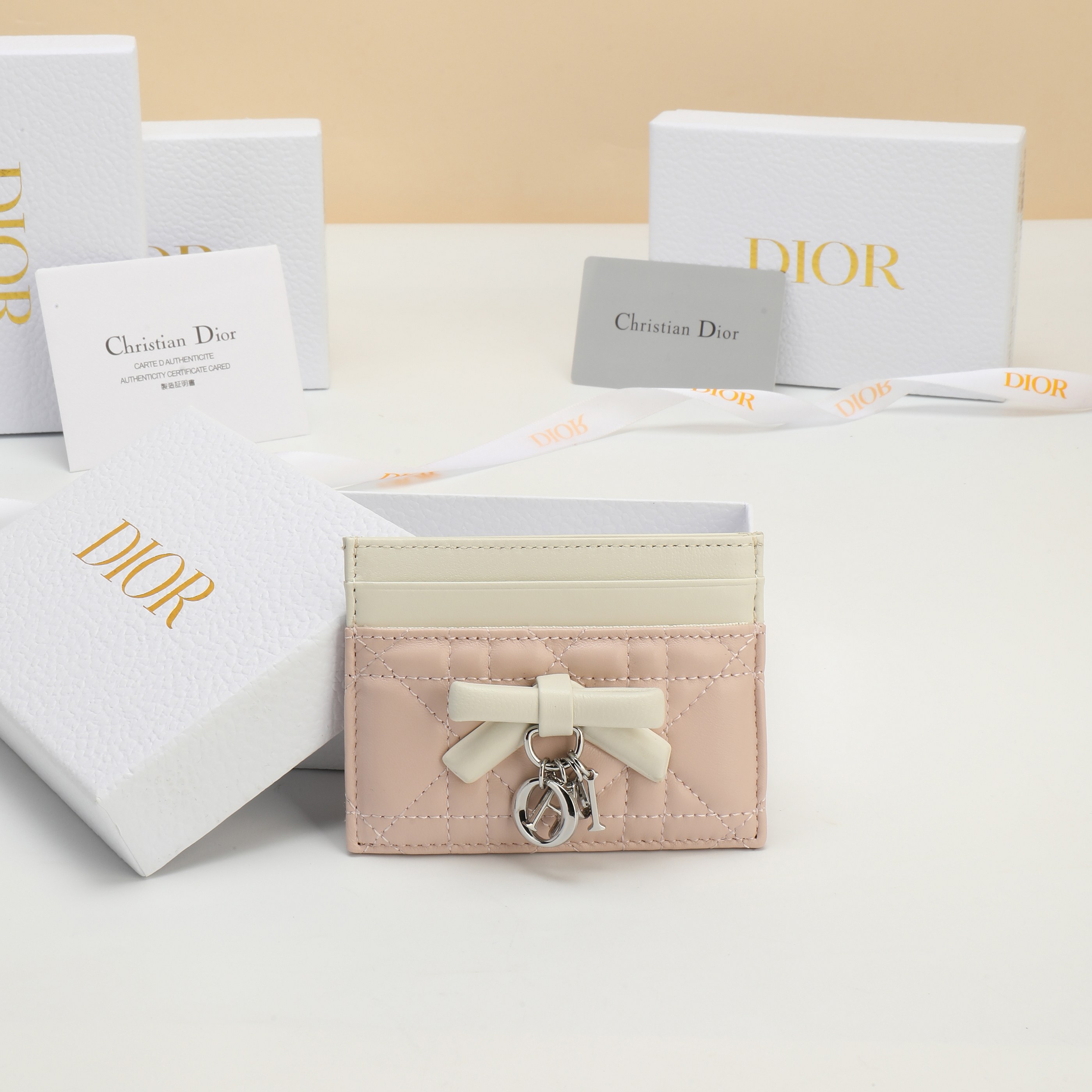 NO:813214,No. S2604OUQA_M900 Dimensions 10.5×8×0.5cm This Lady Dior Freesia card holder is an elegant and practical accessory. Soupir pink and milky white two-tone style, carefully crafted from sheep leather, decorated with cannage pattern topstitching, decorated with a decorative leather bow on the front to enhance the style and matched with a silver finish metal D.I.O.R. charm. Elegant style, suitable for various occasions, with five card slots, which can be used with  Match other items in the Lady Dior series., Dior wallet, dior, wallets, sheepskin19860909编号S2604OUQA_M900 尺寸10.5×8×0.5cm 这款 Lady Dior Freesia卡夹是一款优雅实用的配饰.淡柔粉色 (Soupir pink)和奶白色双色款式,采用羊皮革精心制作,饰以藤格 纹缉面线,正面点缀以装饰性皮革蝴蝶结提升格调搭配银色饰面 金属D.I.O.R.吊饰.款式高雅,适合各种场合,设有五个卡槽,可 与 Lady Dior系列的其他单品搭配.,Dior钱包,dior,wallets,sheepskin,Wallet purse