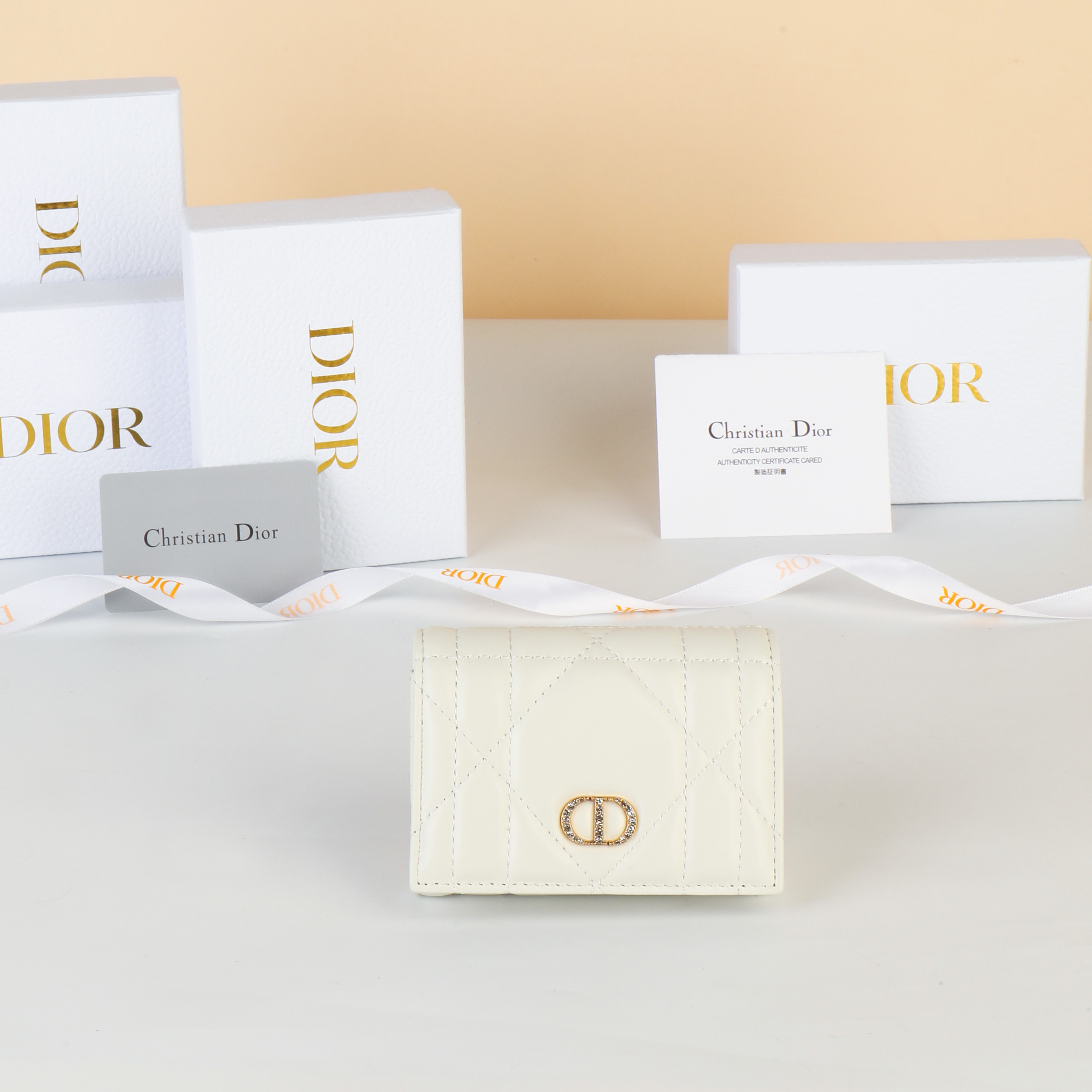 NO:853132,No. S4206UHNN_M413_TU Size 11×7.5×2.5cm This Dior Caro Glycine wallet is a new product in the 2025 autumn and winter ready-to-wear series. It is compact, practical and unique. It is carefully made of milky white sheep leather with oversized cannage pattern topstitching. The front is decorated with a gold-finished metal CD logo paved with exquisite white crystals. The style is elegant and suitable for various occasions. It can store various daily necessities and can also be combined with other  DiorCaro single product matching., Dior wallet, dior, wallets, sheepskin19860909编号S4206UHNN_M413_TU 尺寸11×7.5×2.5cm 这款 Dior Caro Glycine 钱包是二零二五秋冬成衣系列新品,精巧实用,别具一格.采用奶白色羊皮革精心制作,搭配超大藤格纹缉面线,正面饰以密镶以精美白色晶体的金色饰面金属 CD 标志.款式高雅,适合各种场合,可收纳各种日常用品,亦可与其他 DiorCaro 单品搭配.,Dior钱包,dior,wallets,sheepskin,欧美剧