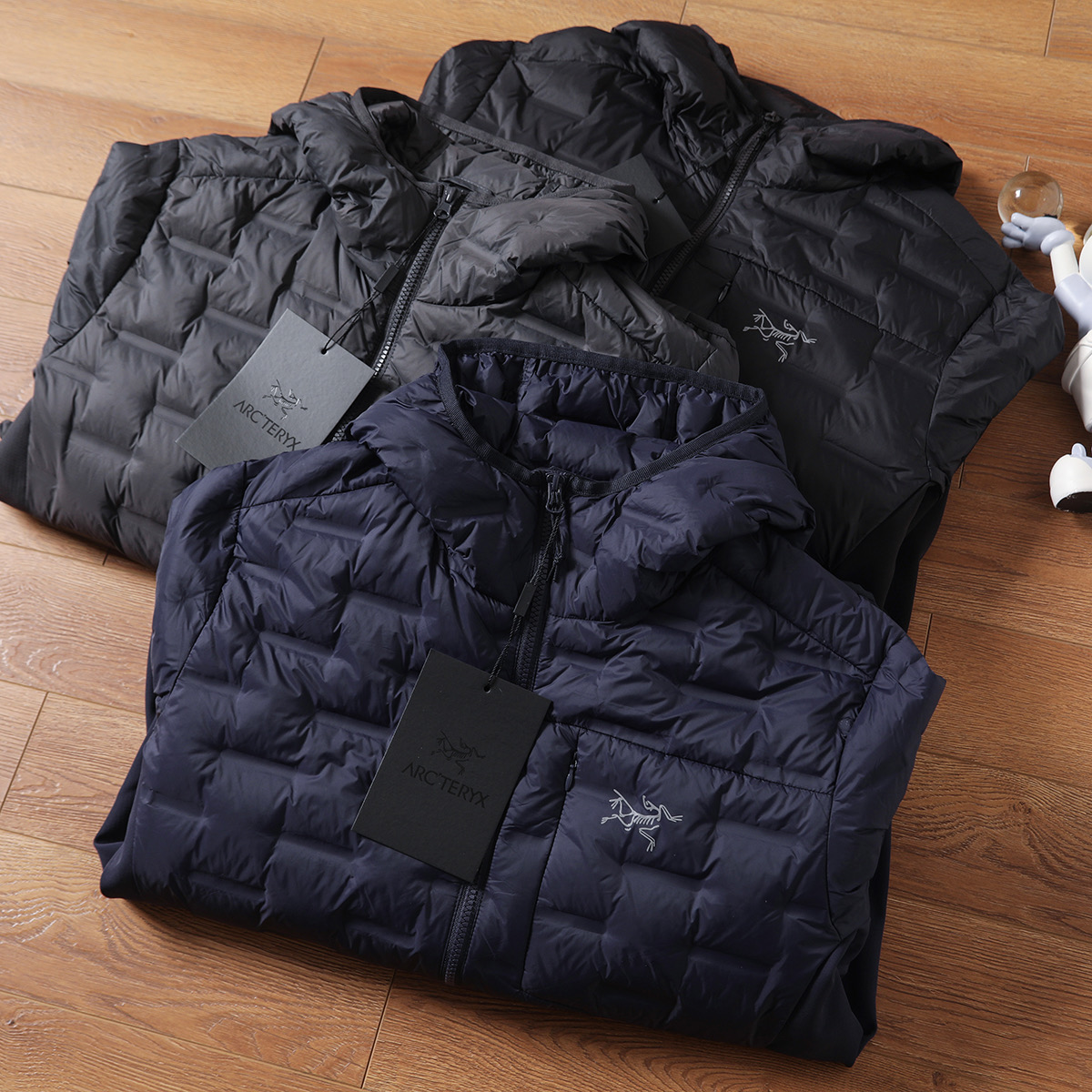 版本🐮货 💰315
ARC'TERYX/始祖鸟轻薄连帽羽绒服，结合轻量化设计与防风防水功能，既满足户外场景的专业需求，又适配日常通勤的便捷性，可拆卸连帽设计更添实用性，男女同款轻松打造情侣默契穿搭。


绒朵大且蓬松度优异，能高效锁住身体热量，即便在0-10℃的户外环境，也能提稳110定保暖。区别于传统厚重羽绒服，它将重量控制在轻量化级别，上身无压身感，打包后体积小巧，可轻松塞进背包，无论是徒步、露营还是日常出行，都不增加携带负担，实现&ldquo;保暖不臃肿，轻便不牺牲温度&rdquo;。

【防风防水面料，应对复杂户外环境】

外层采用高密度防风防水面料，经过专业工艺处理，能有效抵御户外微风与小雨侵袭，避免湿气渗入影响保暖性。日常通勤时，偶遇突如其来的降雨也无需慌乱；户外徒步中，面对山间阵风，面料能紧密阻隔冷空气穿透，让身体始终保持干爽温暖，真正做到&ldquo;一衣应对多变天气&rdquo;。

&bull; 轻量化结构优化：采用简约利落的剪裁，兼顾活动自由度，抬手、弯腰等动作无束缚，男生穿显干练，女生穿显瘦不压个子。

【多场景适配，专业与日常兼顾】

作为户外装备，它可作为外层直接应对温和户外环境，也能作为中间层搭配冲锋衣，适配三层穿衣法应对严寒；日常场景中，通勤、约会、短途旅行穿都合适，轻量化设计让行动更便捷，情侣同穿时，简约版型自带默契感，轻松拿捏&ldquo;户外风情侣穿搭&rdquo;。

无需为大牌溢价妥协，这件鸟家轻薄羽绒服，以国标80绒的硬核保暖、防风防水的专业性能，以及轻量化的实用设计，成为秋冬户外与日常的&ldquo;全能保暖担当&rdquo;。这个季节，无论是奔赴山野还是穿梭城市，让它为你和TA的出行保驾护航商

颜色：黑色、深灰色、藏青色、
尺码：M-3XL

M衣长67肩宽45胸围114(建议115-130斤)

L衣长69肩宽46胸围118(建议130-145斤)

XL衣长70肩宽47胸围122(建议145-160斤)

2XL衣长71肩宽48胸围127(建议160-180斤)

3XL衣长71肩宽49胸围132(建议180-200斤)