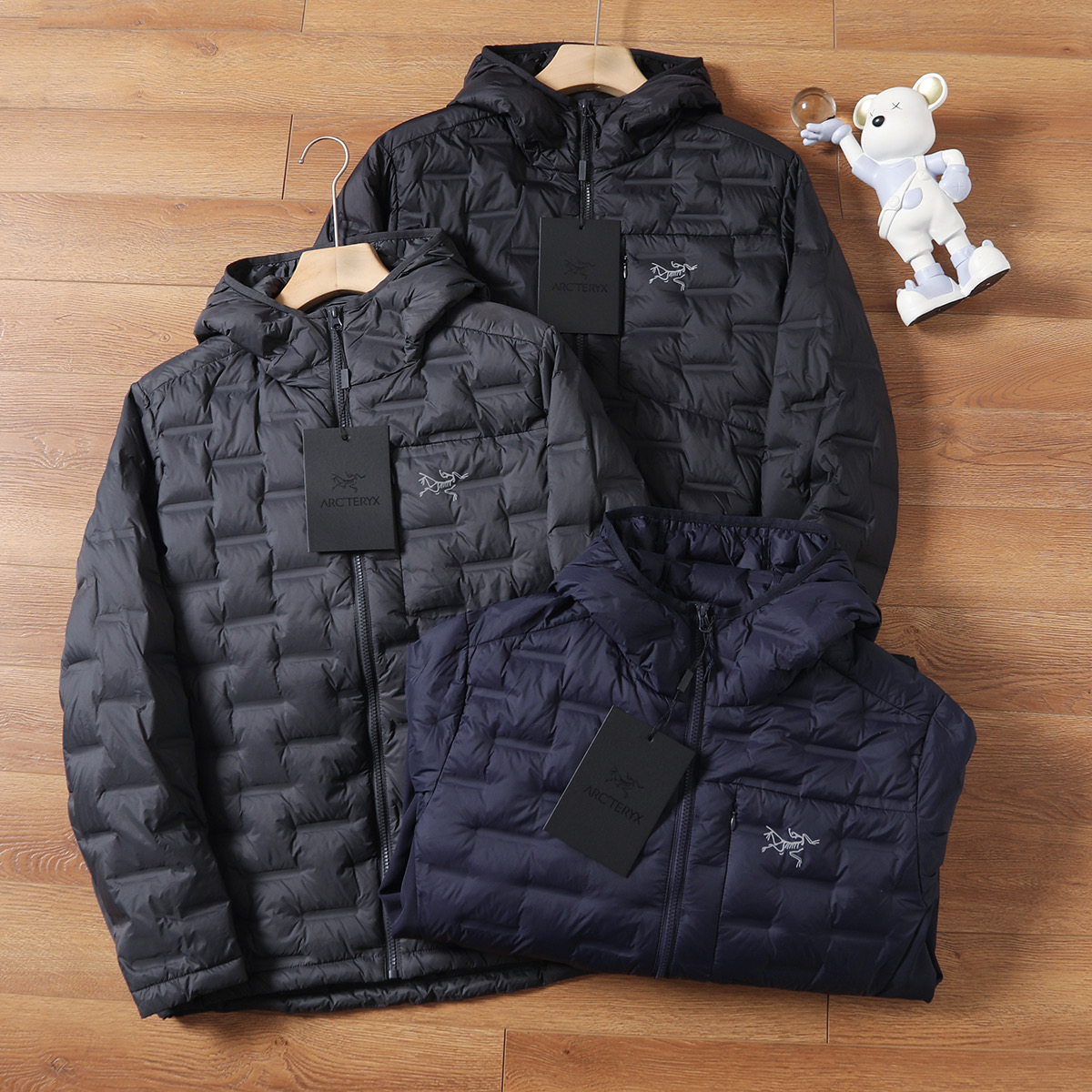 版本🐮货 💰315
ARC'TERYX/始祖鸟轻薄连帽羽绒服，结合轻量化设计与防风防水功能，既满足户外场景的专业需求，又适配日常通勤的便捷性，可拆卸连帽设计更添实用性，男女同款轻松打造情侣默契穿搭。


绒朵大且蓬松度优异，能高效锁住身体热量，即便在0-10℃的户外环境，也能提稳110定保暖。区别于传统厚重羽绒服，它将重量控制在轻量化级别，上身无压身感，打包后体积小巧，可轻松塞进背包，无论是徒步、露营还是日常出行，都不增加携带负担，实现&ldquo;保暖不臃肿，轻便不牺牲温度&rdquo;。

【防风防水面料，应对复杂户外环境】

外层采用高密度防风防水面料，经过专业工艺处理，能有效抵御户外微风与小雨侵袭，避免湿气渗入影响保暖性。日常通勤时，偶遇突如其来的降雨也无需慌乱；户外徒步中，面对山间阵风，面料能紧密阻隔冷空气穿透，让身体始终保持干爽温暖，真正做到&ldquo;一衣应对多变天气&rdquo;。

&bull; 轻量化结构优化：采用简约利落的剪裁，兼顾活动自由度，抬手、弯腰等动作无束缚，男生穿显干练，女生穿显瘦不压个子。

【多场景适配，专业与日常兼顾】

作为户外装备，它可作为外层直接应对温和户外环境，也能作为中间层搭配冲锋衣，适配三层穿衣法应对严寒；日常场景中，通勤、约会、短途旅行穿都合适，轻量化设计让行动更便捷，情侣同穿时，简约版型自带默契感，轻松拿捏&ldquo;户外风情侣穿搭&rdquo;。

无需为大牌溢价妥协，这件鸟家轻薄羽绒服，以国标80绒的硬核保暖、防风防水的专业性能，以及轻量化的实用设计，成为秋冬户外与日常的&ldquo;全能保暖担当&rdquo;。这个季节，无论是奔赴山野还是穿梭城市，让它为你和TA的出行保驾护航商

颜色：黑色、深灰色、藏青色、
尺码：M-3XL

M衣长67肩宽45胸围114(建议115-130斤)

L衣长69肩宽46胸围118(建议130-145斤)

XL衣长70肩宽47胸围122(建议145-160斤)

2XL衣长71肩宽48胸围127(建议160-180斤)

3XL衣长71肩宽49胸围132(建议180-200斤)