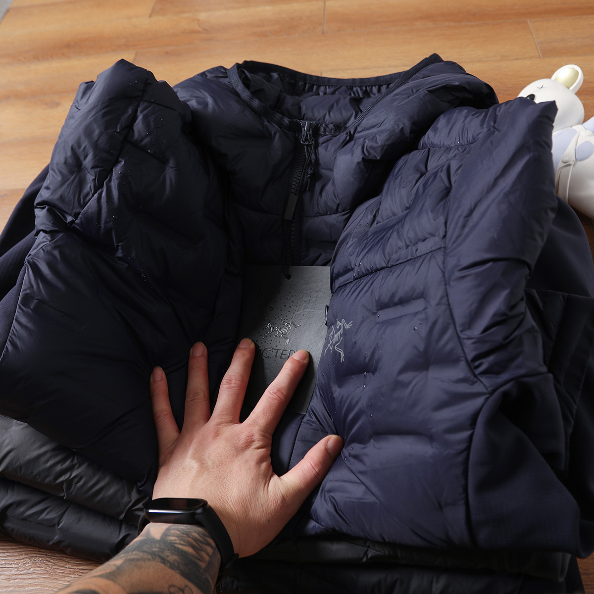 版本🐮货 💰315
ARC'TERYX/始祖鸟轻薄连帽羽绒服，结合轻量化设计与防风防水功能，既满足户外场景的专业需求，又适配日常通勤的便捷性，可拆卸连帽设计更添实用性，男女同款轻松打造情侣默契穿搭。


绒朵大且蓬松度优异，能高效锁住身体热量，即便在0-10℃的户外环境，也能提稳110定保暖。区别于传统厚重羽绒服，它将重量控制在轻量化级别，上身无压身感，打包后体积小巧，可轻松塞进背包，无论是徒步、露营还是日常出行，都不增加携带负担，实现&ldquo;保暖不臃肿，轻便不牺牲温度&rdquo;。

【防风防水面料，应对复杂户外环境】

外层采用高密度防风防水面料，经过专业工艺处理，能有效抵御户外微风与小雨侵袭，避免湿气渗入影响保暖性。日常通勤时，偶遇突如其来的降雨也无需慌乱；户外徒步中，面对山间阵风，面料能紧密阻隔冷空气穿透，让身体始终保持干爽温暖，真正做到&ldquo;一衣应对多变天气&rdquo;。

&bull; 轻量化结构优化：采用简约利落的剪裁，兼顾活动自由度，抬手、弯腰等动作无束缚，男生穿显干练，女生穿显瘦不压个子。

【多场景适配，专业与日常兼顾】

作为户外装备，它可作为外层直接应对温和户外环境，也能作为中间层搭配冲锋衣，适配三层穿衣法应对严寒；日常场景中，通勤、约会、短途旅行穿都合适，轻量化设计让行动更便捷，情侣同穿时，简约版型自带默契感，轻松拿捏&ldquo;户外风情侣穿搭&rdquo;。

无需为大牌溢价妥协，这件鸟家轻薄羽绒服，以国标80绒的硬核保暖、防风防水的专业性能，以及轻量化的实用设计，成为秋冬户外与日常的&ldquo;全能保暖担当&rdquo;。这个季节，无论是奔赴山野还是穿梭城市，让它为你和TA的出行保驾护航商

颜色：黑色、深灰色、藏青色、
尺码：M-3XL

M衣长67肩宽45胸围114(建议115-130斤)

L衣长69肩宽46胸围118(建议130-145斤)

XL衣长70肩宽47胸围122(建议145-160斤)

2XL衣长71肩宽48胸围127(建议160-180斤)

3XL衣长71肩宽49胸围132(建议180-200斤)