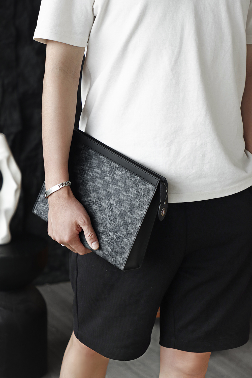 M41696 Classic Black Checkered Pochette Voyage embodies understated luxury, serving both as a sophisticated clutch and a practical travel toiletries bag for versatile use