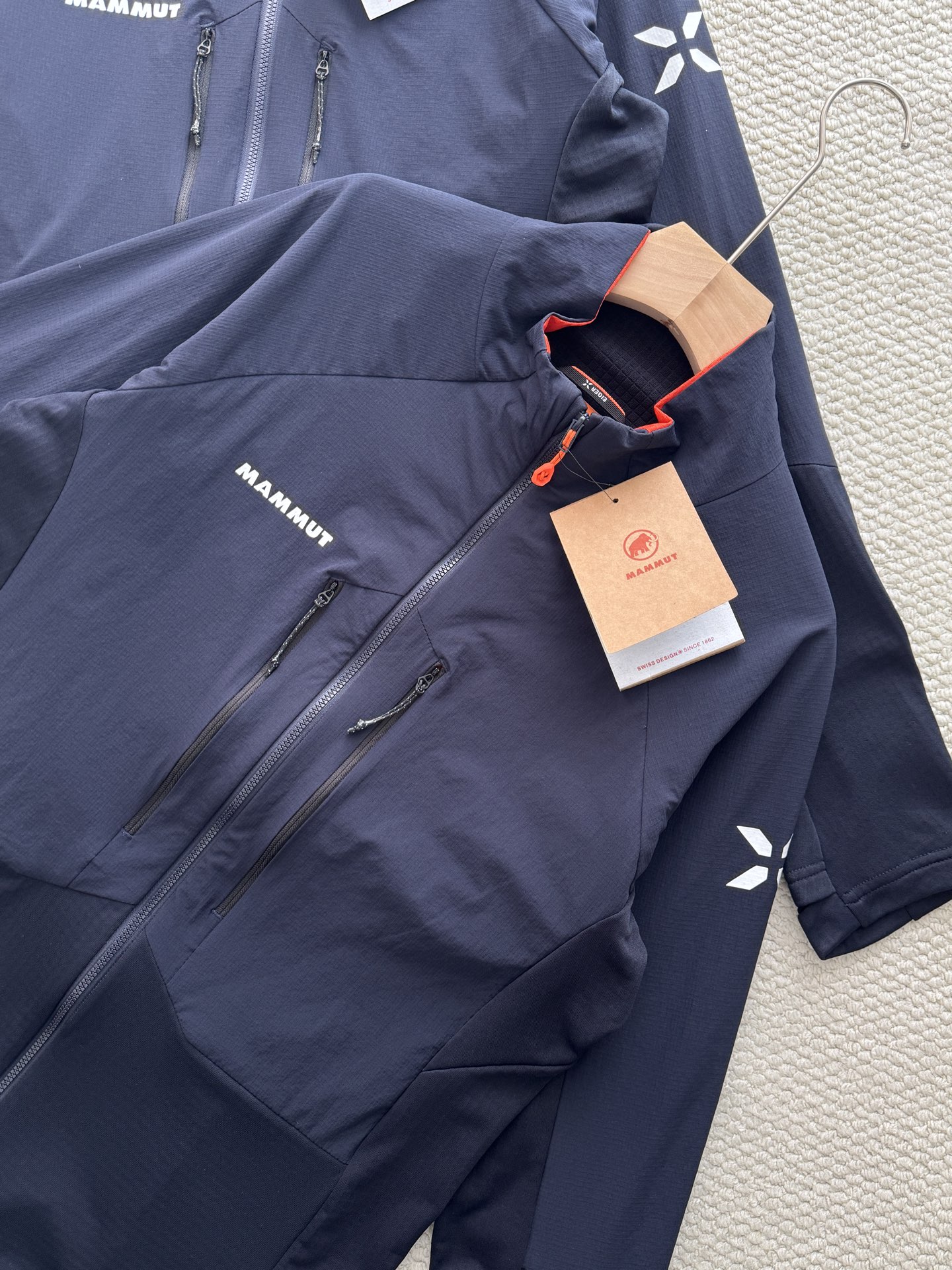 💰165
Mammut Eiger Nordwand ML Hybrid猛犸象艾格系列男款轻量棉抓绒

颜色：藏青
尺码：m~xxl

设计细节拉满：采用立领剪裁搭配半开拉链（主拉链全开设计），领口内侧的橙色撞色点缀，打破藏青纯色的沉闷；左胸品牌字母标识、袖侧的大象logo简约又具辨识度，拉链口袋的隐形设计既保证实用性又不破坏整体版型，肩部与衣身的拼接剪裁更贴合人体工学，活动无束缚。

功能性硬核在线：主打轻量化抓绒面料，兼顾保暖性与透气性，秋冬单穿锁温不闷汗，作为中间层搭配冲锋衣也不会显得臃肿；面料具备一定的抗风性，徒步、登山等户外场景能有效抵御冷风，拉链口袋还可收纳小物件，兼顾户外实用性与日常便携性。

款式适配多场景：经典藏青配色属于百搭色系，无论是户外徒步、城市通勤还是日常休闲，都能轻松搭配牛仔裤、运动裤等下装；修身不紧身的版型对不同身材友好，男生女生穿都能穿出利落的户外风格，是秋冬衣橱里的&ldquo;万金油&rdquo;单品。
