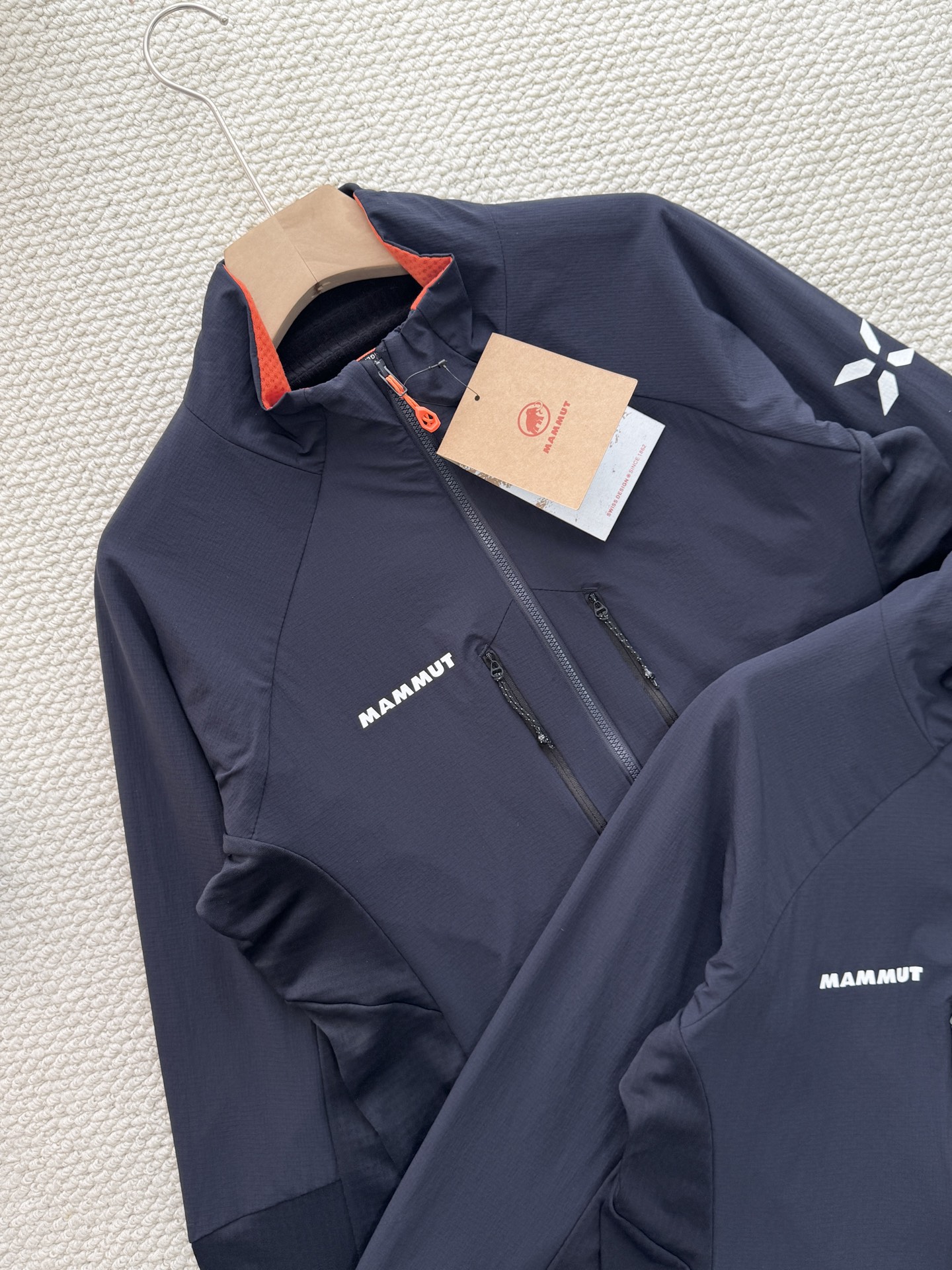 💰165
Mammut Eiger Nordwand ML Hybrid猛犸象艾格系列男款轻量棉抓绒

颜色：藏青
尺码：m~xxl

设计细节拉满：采用立领剪裁搭配半开拉链（主拉链全开设计），领口内侧的橙色撞色点缀，打破藏青纯色的沉闷；左胸品牌字母标识、袖侧的大象logo简约又具辨识度，拉链口袋的隐形设计既保证实用性又不破坏整体版型，肩部与衣身的拼接剪裁更贴合人体工学，活动无束缚。

功能性硬核在线：主打轻量化抓绒面料，兼顾保暖性与透气性，秋冬单穿锁温不闷汗，作为中间层搭配冲锋衣也不会显得臃肿；面料具备一定的抗风性，徒步、登山等户外场景能有效抵御冷风，拉链口袋还可收纳小物件，兼顾户外实用性与日常便携性。

款式适配多场景：经典藏青配色属于百搭色系，无论是户外徒步、城市通勤还是日常休闲，都能轻松搭配牛仔裤、运动裤等下装；修身不紧身的版型对不同身材友好，男生女生穿都能穿出利落的户外风格，是秋冬衣橱里的&ldquo;万金油&rdquo;单品。
