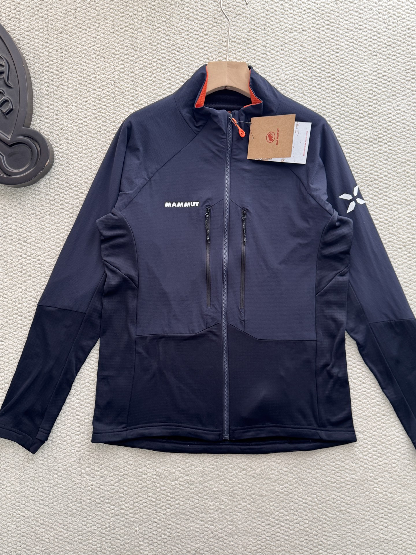 💰165
Mammut Eiger Nordwand ML Hybrid猛犸象艾格系列男款轻量棉抓绒

颜色：藏青
尺码：m~xxl

设计细节拉满：采用立领剪裁搭配半开拉链（主拉链全开设计），领口内侧的橙色撞色点缀，打破藏青纯色的沉闷；左胸品牌字母标识、袖侧的大象logo简约又具辨识度，拉链口袋的隐形设计既保证实用性又不破坏整体版型，肩部与衣身的拼接剪裁更贴合人体工学，活动无束缚。

功能性硬核在线：主打轻量化抓绒面料，兼顾保暖性与透气性，秋冬单穿锁温不闷汗，作为中间层搭配冲锋衣也不会显得臃肿；面料具备一定的抗风性，徒步、登山等户外场景能有效抵御冷风，拉链口袋还可收纳小物件，兼顾户外实用性与日常便携性。

款式适配多场景：经典藏青配色属于百搭色系，无论是户外徒步、城市通勤还是日常休闲，都能轻松搭配牛仔裤、运动裤等下装；修身不紧身的版型对不同身材友好，男生女生穿都能穿出利落的户外风格，是秋冬衣橱里的&ldquo;万金油&rdquo;单品。
