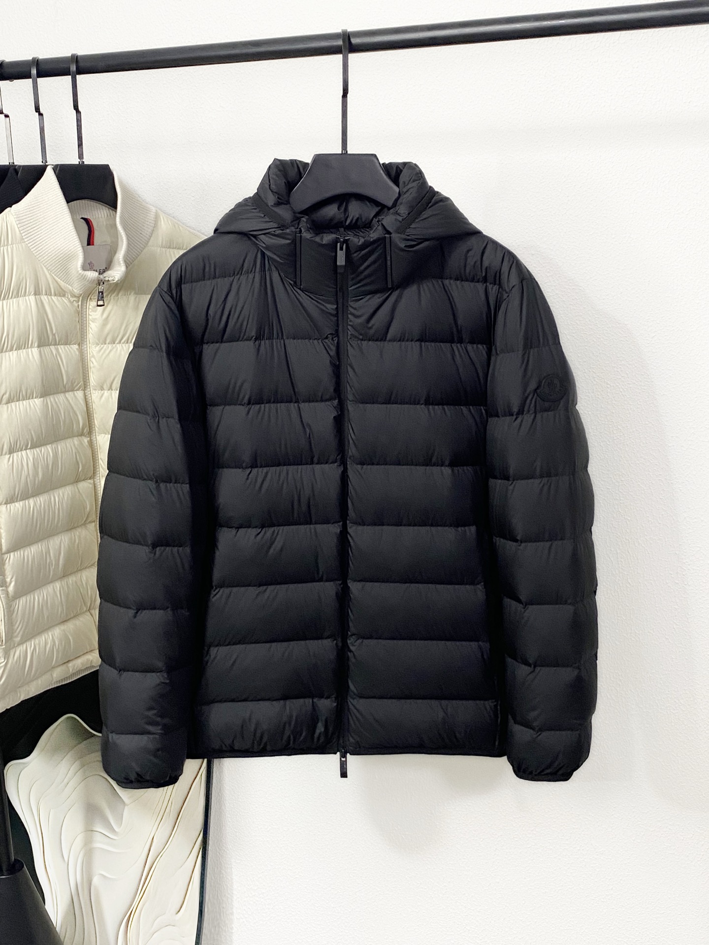 NO:611455,Monc's fashionable and simple quilted hooded down jacket for autumn and winter is ordered through overseas trade channels, shipped directly from the warehouse in Hong Kong, China, and is sold in limited quantities. This simple quilted down jacket is made of high-density nylon material and filled with 90% goose down, which is light and warm! The hooded design + black zipper is simple and elegant. The cuffs and hem are elasticated and have a great windproof effect.  The sleeve arms are decorated with the brand's classic silicone logo, which is low-key and recognizable. It is suitable for daily commuting and outdoor use. Pair it with jeans or casual pants to easily get a warm and fashionable look. Color white/black Size: 1-5 Unit cm Data reference: 1 Shoulder width 49 Bust 116 Clothing length 68 2 Shoulder width 50 Bust 120 Clothing length 69 3 Shoulder width 51 Bust 124 Clothing length 70 4 Shoulder width 52  Bust 128 Length 71 5 Shoulder Width 53 Bust 132 Length 72 Manual measurement, error within 1-3CM is normal, Moncler, jeans, down jacket, hats, alexander wang19860909Monc 蒙口家秋冬款时尚简约绗缝连帽羽绒服 海外贸易渠道订购,中国香港仓直发,精品限量销售. 这款简约绗缝羽绒服,采用高密度尼龙材质加上90鹅绒填充,轻盈又保暖!连帽设计+黑色拉链,简约大气,袖口和下摆松紧收口,防风效果棒棒哒. 袖臂上装饰有品牌经典硅胶标志,低调有辨识度.日常通勤、户外都适合,搭配牛仔裤或休闲裤,轻松get温暖时髦look. 颜色白色/黑色 尺码:1-5 单位cm 数据参考: 1肩宽49 胸围116 衣长68 2肩宽50 胸围120 衣长69 3肩宽51 胸围124 衣长70 4肩宽52 胸围128 衣长71 5肩宽53 胸围132 衣长72 手工测量 误差1-3CM内实属正常,,Moncler,jeans,down jacket,hats,alexander wang,Men's clothing