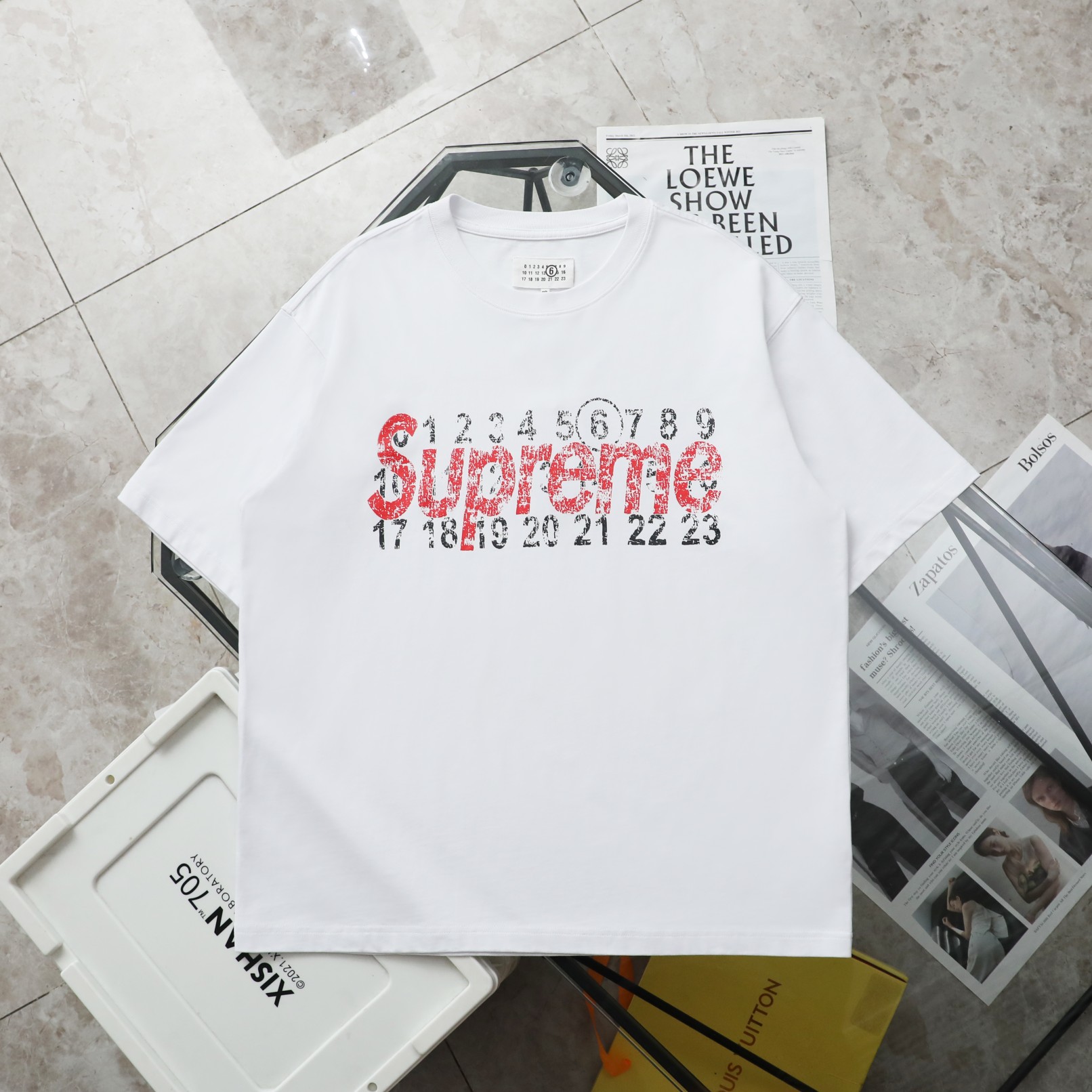 【纯原臻品 顶级复刻】\nMaison Margiela/马吉拉supreme联名短袖T恤\n- 款号：0\n- 颜色：黑色 白色 \n- 购入原版开模打造，全套定制辅料，细节决定成败\n- 马丁·马吉拉（Martin Margiela，年月日－）是比利时服装设计师，出生于比利时亨克。和比利时前卫风格-安特卫普六君子皆为安特卫普皇家艺术学院毕业学生。个人品牌为 Maison Martin Margiela Maison为（法文'家'的意思），并于ZD年正式宣布推出[]他个人品牌。于年月正式更名为Maison Margiela。[]\n- 面料：ZB克定制双纱高密度纯棉面料\n- 工艺: 整件衣服采用精密压花工艺\n- 辅料：全套马吉拉原版专柜辅料\n- 男女同款均可驾驭\n- 尺码：S～XL\nS: 衣长 胸围???????????? 肩宽 袖长\nM: 衣长 胸围肩宽 袖长\nL: 衣长