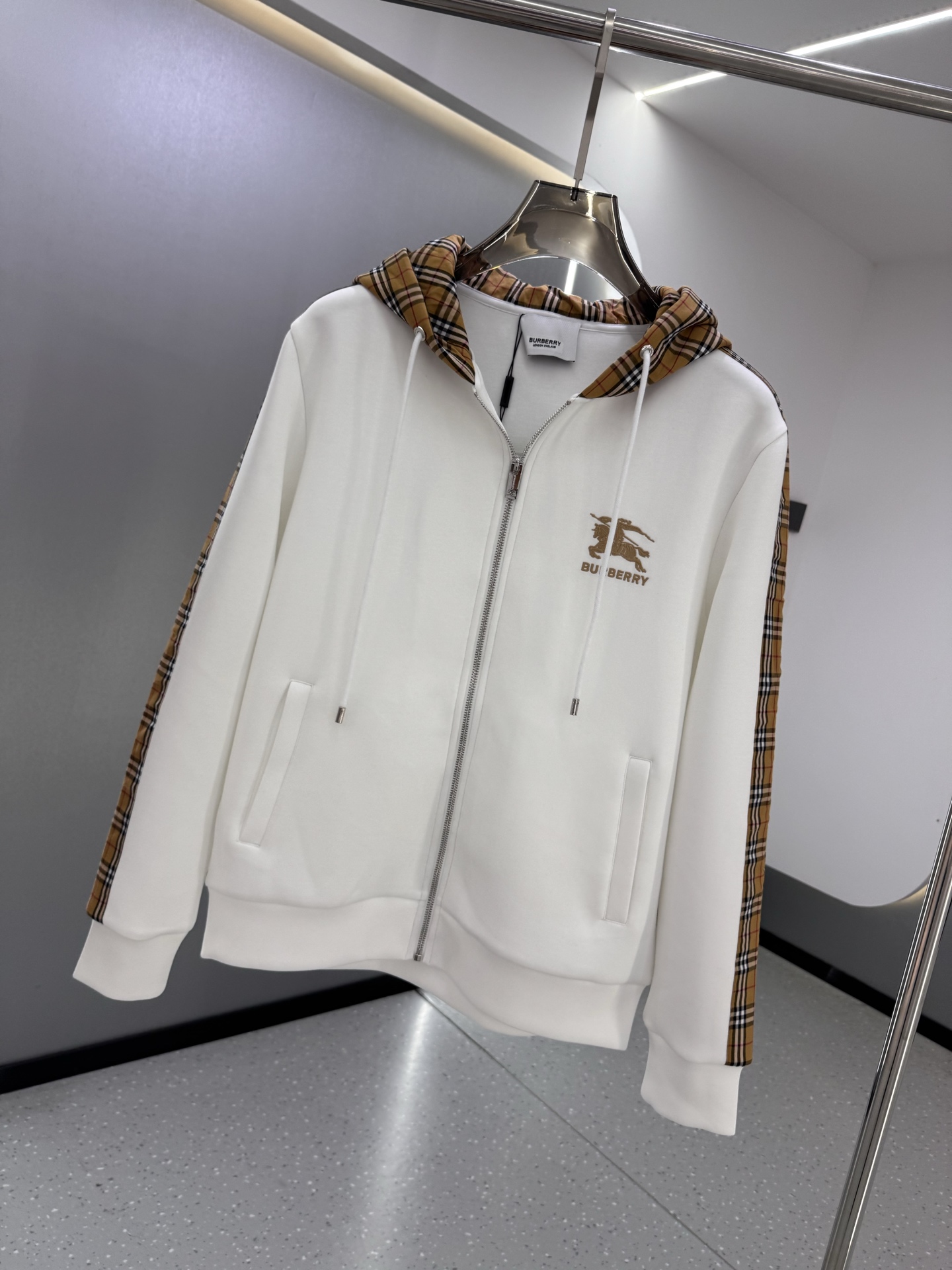P350  BBR 25ss秋冬新款Vintage格纹裁片棉质连帽卫衣，格纹拼接情侣款卫衣，百搭高克数纯棉连帽卫衣！这款翻面绒棉质卫衣外套，设有对比感连帽。衣袖裁片采用 Vintage 复古格纹羊毛棉质混纺法兰绒面料，绣有 Thomas Burberry 专属标识。外形清爽干练,浅灰色净面搭配巴宝莉的经典格子设计真的太爱了，经典格子设计由帽子延伸到手臂，两边的手臂完美对称,整衣格纹定位裁剪，胸口BT小刺绣,低调又高级~完全遵循zg的材质厚度，所以上身整体层次感非常强烈，不像市场版本采用了市场面料非常薄上身完全没有垂坠感！这种时髦个性的印花刺绣设计加上抽绳处采用了激光雕刻的五金
完美的彰显了BUR品牌的存在感，极具辨识度整体给人一种简约高规又基础
并且整体更是采用宽松版型打造，时尚跟高街休闲风格更强！！550克洗手面料，份量感十足，柔软舒适是基本，透气度和保暖度兼并才是惊喜！整体的触感极为舒适，亲肤效果也是极佳。OV版型方面也是完美穿搭效果，完美的符合各种穿搭场合的所需。极为非凡，档次与魅力更是极为的出色亮眼，更能够彰显品牌规格与你对于时尚的追求！！期待各位粉丝的完美演绎！！黑色，白色 M-XXXL
