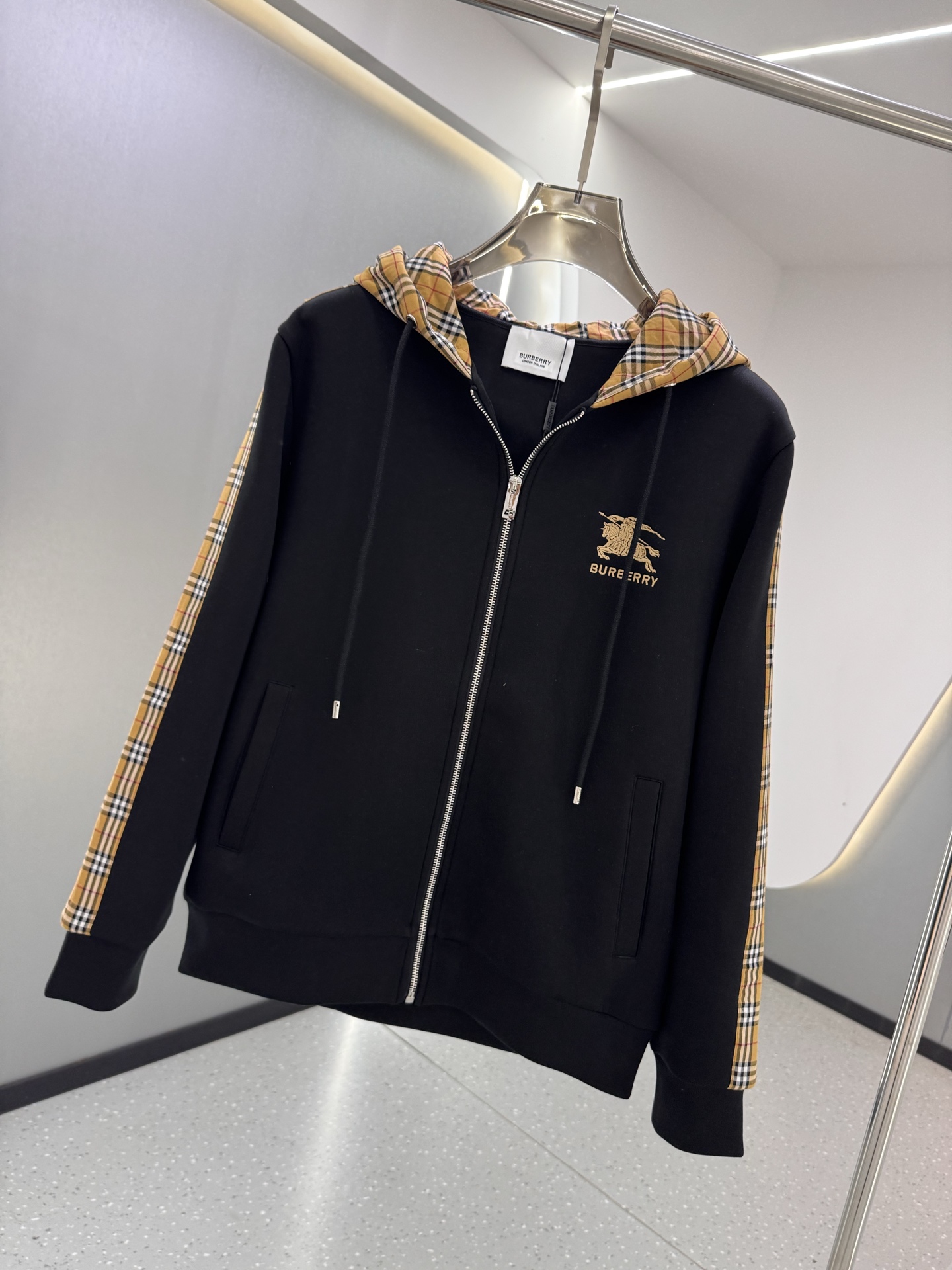 P350  BBR 25ss秋冬新款Vintage格纹裁片棉质连帽卫衣，格纹拼接情侣款卫衣，百搭高克数纯棉连帽卫衣！这款翻面绒棉质卫衣外套，设有对比感连帽。衣袖裁片采用 Vintage 复古格纹羊毛棉质混纺法兰绒面料，绣有 Thomas Burberry 专属标识。外形清爽干练,浅灰色净面搭配巴宝莉的经典格子设计真的太爱了，经典格子设计由帽子延伸到手臂，两边的手臂完美对称,整衣格纹定位裁剪，胸口BT小刺绣,低调又高级~完全遵循zg的材质厚度，所以上身整体层次感非常强烈，不像市场版本采用了市场面料非常薄上身完全没有垂坠感！这种时髦个性的印花刺绣设计加上抽绳处采用了激光雕刻的五金
完美的彰显了BUR品牌的存在感，极具辨识度整体给人一种简约高规又基础
并且整体更是采用宽松版型打造，时尚跟高街休闲风格更强！！550克洗手面料，份量感十足，柔软舒适是基本，透气度和保暖度兼并才是惊喜！整体的触感极为舒适，亲肤效果也是极佳。OV版型方面也是完美穿搭效果，完美的符合各种穿搭场合的所需。极为非凡，档次与魅力更是极为的出色亮眼，更能够彰显品牌规格与你对于时尚的追求！！期待各位粉丝的完美演绎！！黑色，白色 M-XXXL
