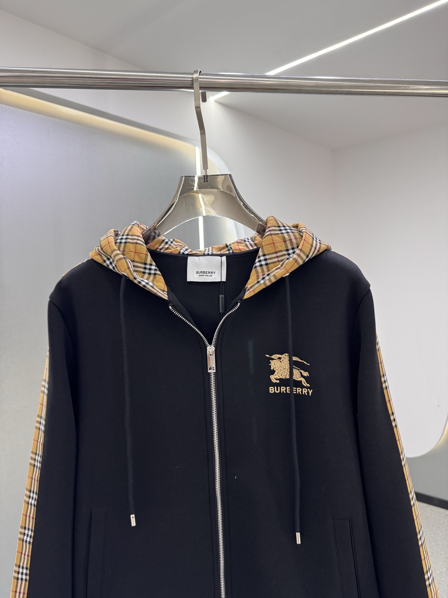 P350  BBR 25ss秋冬新款Vintage格纹裁片棉质连帽卫衣，格纹拼接情侣款卫衣，百搭高克数纯棉连帽卫衣！这款翻面绒棉质卫衣外套，设有对比感连帽。衣袖裁片采用 Vintage 复古格纹羊毛棉质混纺法兰绒面料，绣有 Thomas Burberry 专属标识。外形清爽干练,浅灰色净面搭配巴宝莉的经典格子设计真的太爱了，经典格子设计由帽子延伸到手臂，两边的手臂完美对称,整衣格纹定位裁剪，胸口BT小刺绣,低调又高级~完全遵循zg的材质厚度，所以上身整体层次感非常强烈，不像市场版本采用了市场面料非常薄上身完全没有垂坠感！这种时髦个性的印花刺绣设计加上抽绳处采用了激光雕刻的五金
完美的彰显了BUR品牌的存在感，极具辨识度整体给人一种简约高规又基础
并且整体更是采用宽松版型打造，时尚跟高街休闲风格更强！！550克洗手面料，份量感十足，柔软舒适是基本，透气度和保暖度兼并才是惊喜！整体的触感极为舒适，亲肤效果也是极佳。OV版型方面也是完美穿搭效果，完美的符合各种穿搭场合的所需。极为非凡，档次与魅力更是极为的出色亮眼，更能够彰显品牌规格与你对于时尚的追求！！期待各位粉丝的完美演绎！！黑色，白色 M-XXXL
