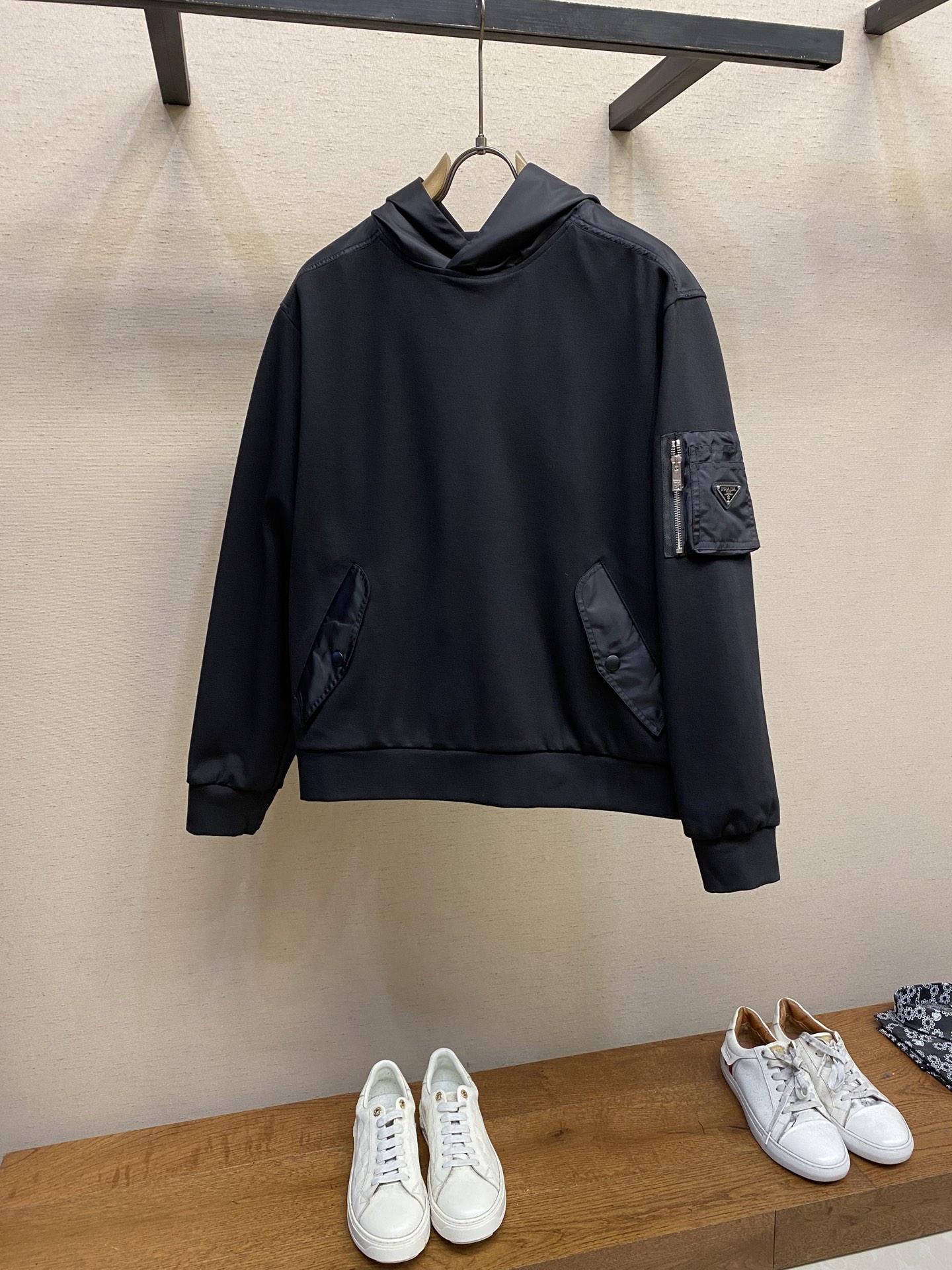 NO:121530,Prada, cotton fleece and recycled nylon hooded sweatshirt This main fabric is cotton fleece. The surface fibers of the fabric are specially treated to produce a large amount of fine fluff. This fabric has the characteristics of warmth, windproof, lightweight, and easy to dry. In the shoulder position, the hood and arm bag use the brand's classic recycled nylon fabric. Craft 1 The hood uses recycled nylon as the hat shell, which is easier to shape due to the uniqueness of nylon. Then, according to the shape of the hat shell, cotton fleece is used as the inner lid, and invisible sewing is used to sew the main body of the hat to make it more beautiful. The neckline of the hat is overlapped front and back to better fit the face and achieve windproof performance.  Craft 2 has functional arm bags on the sleeves, the bag body is cut in three-dimensional, and the main body bag mouth is waterproof zipper to ensure the safety of the items. The arm bag and sleeve use seamless splicing technology to reduce friction, and the edge of the bag reinforces the stitching to enhance durability; an open pocket is also sewn on the main bag, and triangular markings are added to enhance recognition. Craft 3 has a brand classic pentagonal flap made of recycled nylon fabric, which is fixed with snaps to prevent items from falling. The edge of the flip is edged to prevent disconnection and maintain a neat appearance. Size S-XL, prada, hats, alexander wang19860909Prada、棉质抓绒和再生尼龙连帽运动衫 这款主体面料为棉质抓绒,将面料表面纤维经过特殊处理,使其产生大量的细小绒毛,这种面料具有保暖、防风、轻量、易干等特点；在肩位,风帽和臂袋使用品牌经典的再生尼龙面料 工艺1风帽采用再生尼龙作为帽壳,因尼龙的独特性更易塑形,再根据帽壳的形状,采用棉质抓绒作为内里,运用隐形缝制将帽子主体缝合,使其更具美观度.帽子领口处做了前后重叠,更好的贴合面部,做到防风性能. 工艺2袖子上带有功能性臂袋,袋体采用立体剪裁,主体袋口使用防水拉链,确保物品安全.臂袋与袖子采用无缝拼接技术,减少摩擦,袋口边缘加固缝线,增强耐用性；主袋上面还缝制了一个开口袋,再加以三角标点缀,提升辨识度. 工艺3前身带有左右侧袋,再生尼龙面料制成的品牌经典五边形翻盖,加以按扣固定,防止物品掉落.翻盖边缘做了包边,防止脱线并保持整洁外观 尺码S-XL,,prada,hats,alexander wang,Men's clothing