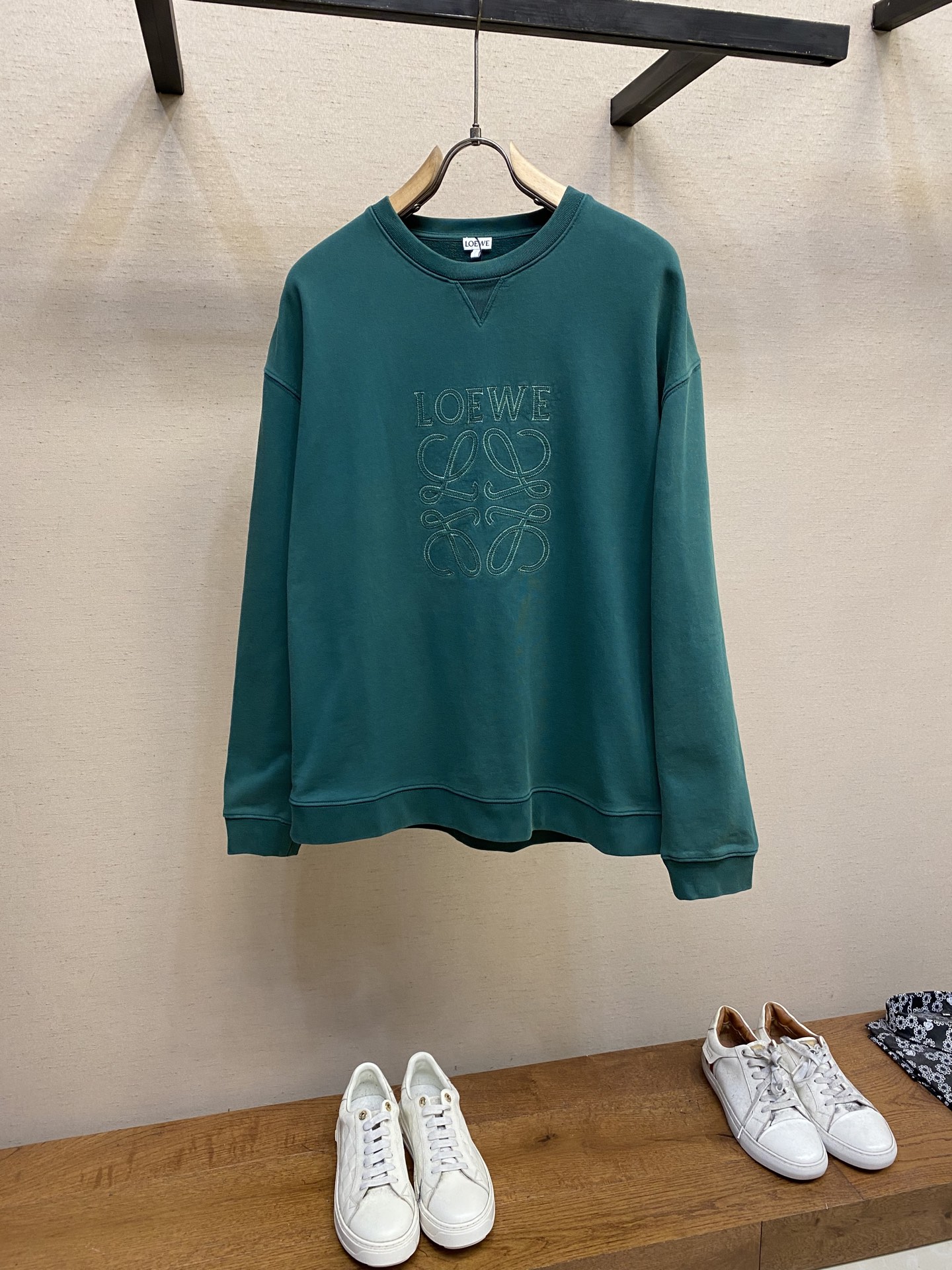 NO:131459,Loewe, LOE serrated thread patch round neck sweatshirt is available in green and gray color, original, 800 purchase; medium-sized cotton loop fleece fabric, chest with laser-cut applique, loose fit, standard length, rib-knit collar, cuffs and hem, front V-shaped details, full set of auxiliary materials equipped # medium-sized cotton loop fleece fabric uses 16S single yarn S single yarn fish scale fixed sweatshirt fabric, 380g paired with 21S 2*2 threads, 470g. The fish scale bottom fabric forms a fish scale-like foundation through a specific weaving process, and the plates are arranged and interwoven according to the warp and weft rules and shapes to ensure clear texture and excellent texture. The fabric has been finely made and processed, with good durability, lightness, softness, and breathability. # The chest is decorated with laser-cut applique  The edges of the patch embroidery strengthen branches, and by imitating the serrated stitches in the form of serrated shapes, the rough industrial vision is increased. The patch embroidery stitches are trapezoidal, shaped like canine teeth intertwined; emphasize the high density of stitches and sharp twists, such as saw blade cutting traces. Cut off excess fabric along the dog floss stitches, retaining the three-dimensional sense of serrated serrated. # Fried sand and old process are made after the garment is frying. The garment is transformed and dyed, and washed and old. The fabric is dyed and processed through the stone mill, and the garment is constantly immersed in the dye and rolled. The fabric is slightly faded after the sand, and the original fabric color changes, which shows nostalgic colors of different shades and light and darkness. # V-shaped details on the front  A structural feature formed by the neckline adopts a V-shaped rib weaving method, which has a unique visual sense of line and extension. The rib structure itself has good elasticity and elasticity; the seams of the shoulder thread are inserted to increase service life. The neckline, hem, and cuffs are spliced ​​with thread threads of the kali double needles, and the large body and sleeve tube are structurally quilted, and the fabric material has a ductility and unrestrained sense. Size XS-L Colors green, gray, loewe, hoodie, sweatshirts, alexander wang19860909Loewe,LOE锯齿线贴布圆领卫衣 发售色系绿色、灰色 原,800购买；中克重棉质回圈抓绒面料、胸前饰有激光切割贴花、宽松版型、标准长度、罗纹针织衣领、袖口和下摆 、正面V形细节、全套辅料配备 # 中克重棉质回圈抓绒面料 采用16S单纱S单纱鱼鳞定卫衣面料,380g搭配21S 2*2螺纹,470g.鱼鳞底面料通过特定的织造工艺形成鱼鳞状底纹,对版按照经纬规律和形状进行排列交织,以确保纹理清晰、质地优良.面料经过精细的制作加工,具有良好的耐穿性、轻薄柔软、透气性好. # 胸前饰有激光切割贴花 贴布绣的边缘强化分支,通过模仿锯齿形态的线迹,增加粗犷工业风视觉.贴布绣线迹呈梯形锯齿,形似犬齿交错；强调线迹密度高、转折锋利,如锯条切割痕迹.修剪缝份沿狗牙线迹剪去多余布料,保留锯齿立体感. # 炒砂做旧工艺 成衣后进行炒色工艺制作而成,成衣环保新工艺转染染色、洗水做旧.通过石磨的方式对面料进行染色加工,成衣不断地浸入染料中翻滚.炒砂后面料轻微掉色效果,改变原面料颜色呈现出深浅一明暗不同的怀旧色彩. # 正面V形细节 领口采用V形排列的罗纹编织方式所形成的一种结构特点,在视觉上具有独特的线条感和延伸性.罗纹结构本身具有较好的弹性和伸缩性；肩线做缝处均内加嵌条,增加使用寿命.领口、下摆、袖口均以坎车双针车线螺纹拼接,大身及袖管结构性切分绗缝,面料材质具有的延展性无约束感. 尺码XS-L 颜色绿色,灰色,,loewe,hoodie,sweatshirts,alexander wang,Men's clothing