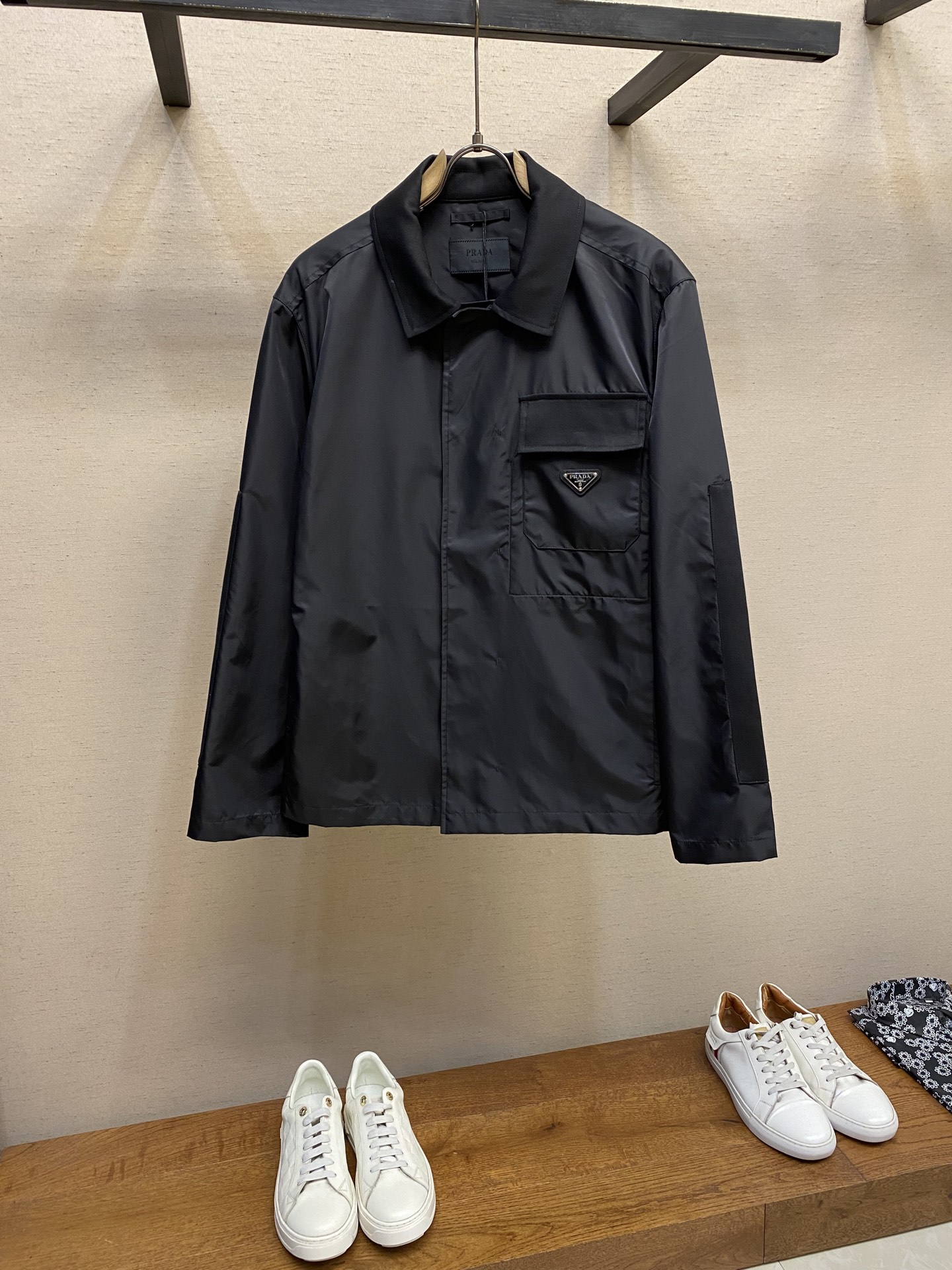 NO:137664,Prada, recycled nylon lapel jacket fabric selection The brand's iconic recycled nylon fabric is comparable to traditional nylon, with high strength, tear resistance, wear resistance and other characteristics. Its texture is light and waterproof, and is suitable for multiple scenarios. Its wrinkle resistance and quick drying are also easy to maintain and maintain daily. Process and details  Straight sleeves and shoulder cuts form smooth lines, paired with a flat bottom edge design, highlighting minimalism. The cotton twill shirt lapel is used to form a texture contrast with the recycled nylon body. The soft and skin-friendly cotton balances the tough and technological sense of nylon. The hidden snap buckle makes it more beautiful. There is a patch pocket on the left chest, and a twill ginger flap highlights the layering, and the enamel triangle mark is decorated on the bag body to enhance visual recognition. The inner seam pocket is integrated into the body with a hidden process, taking into account practicality and visual purity. The pocket tucks are reinforced by the end of the side pocket opening and closing to increase durability. Abandon traditional linings, and the contour is shaped with the crispness of the fabric itself, reducing redundant layers while improving breathability. Size S-XL,,prada, jackets & coats,shirts,alexander wang19860909Prada、再生尼龙翻领外套 面料选择 选用品牌标志性的再生尼龙面料,与传统尼龙性能相当,具备高强度,抗撕裂,耐磨损等特性.其质地轻盈,同时又具备防水功能适合多场景需求.抗皱,快干的特点也易于日常打理维护. 工艺与细节 直筒衣袖与落肩剪裁形成流畅线条,搭配平直底边设计,凸显极简主义.采用棉质斜纹布衬衫翻领与再生尼龙主体形成质感对比,棉质的柔软亲肤平衡了尼龙的硬朗科技感.隐藏式按扣开合使其更具美感.左胸口设有贴袋,搭配斜纹格布翻盖凸显层次感,将涂珐琅三角标饰以袋体之上,强化视觉辨识度.内接缝口袋以隐藏式工艺融入衣身,兼顾实用性和视觉纯净感.侧插袋口首尾均运用口袋套结工艺加固,增加耐用性.摒弃传统衬里,以面料本身的挺括度塑造廓形,减少冗余层次的同时提升透气性. 尺码S-XL,,prada,jackets & coats,shirts,alexander wang,Men's clothing