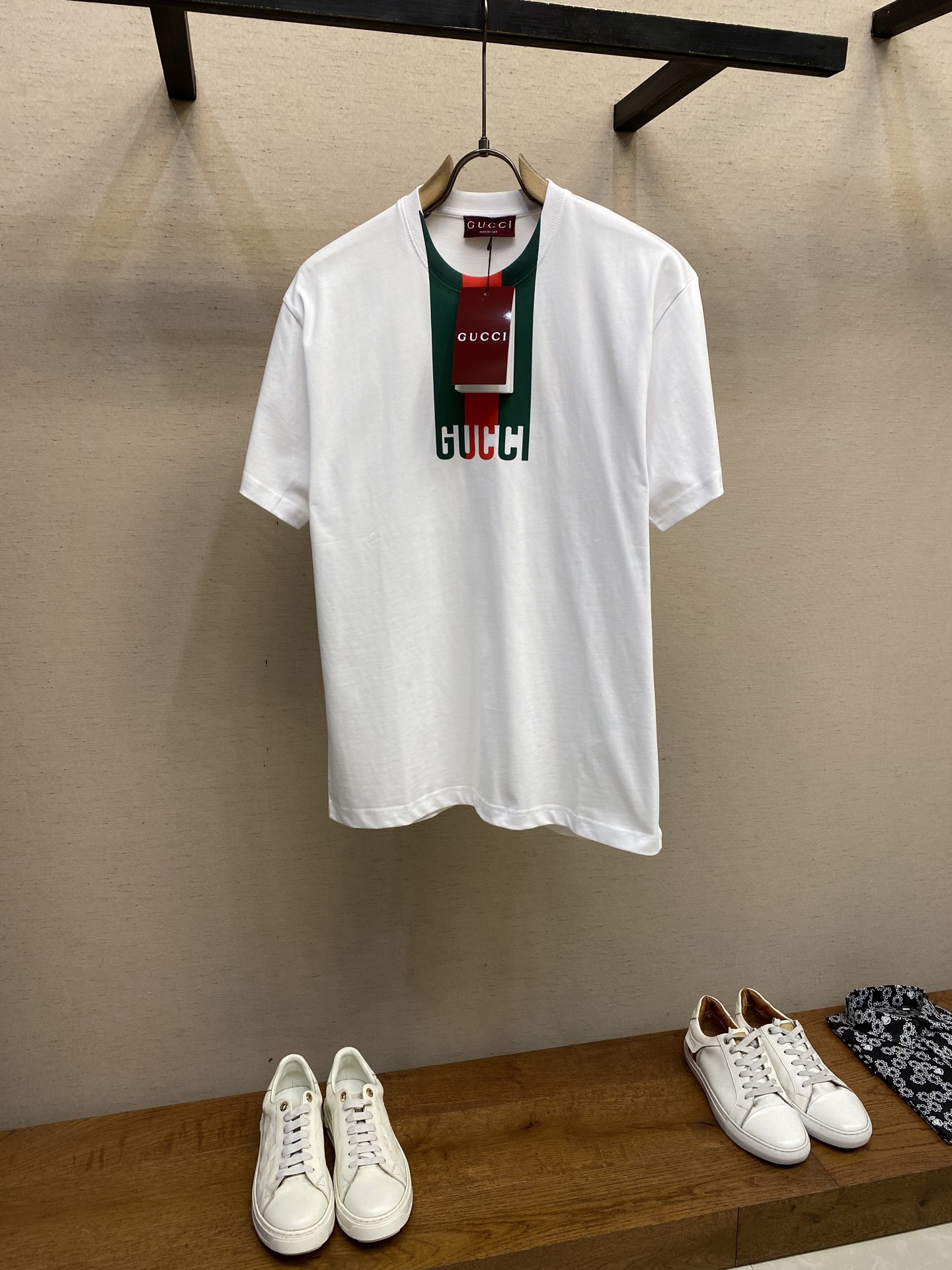 NO:141488,Gucci, GU collar printed round neck short sleeves Original, 700 purchase; White fine velvet knitted cotton, Gu webbing printing, round neck short sleeves, ribbed piping, full set of auxiliary materials equipped with # Pure cotton knitted plain fabric uses 15S fine cotton plain fabric, 230g; matched with 32S double yarn thread, 300g. Plain weave fabric made of cotton fiber treated with combed process, compared with ordinary cotton fabrics, its fiber arrangement is more neat and dense, so it has better texture and luster. 15S fine cotton plain fabric is a high-quality cotton fabric, which has the characteristics of softness and comfort, good breathability, and good durability. # Gu webbing pattern silicone printing  Silicone pad penetration printing process is a process that combines the characteristics of silicone material and printing technology. The surface forms a durable pattern. The rubber surface has a microporous structure. By adjusting the ink flowability and applying pressure, the ink penetrates into the surface of the silicone to form a mechanical anchor. At the same time, the ink residence time is controlled to prevent excessive diffusion and cause blurred pattern. # Round neck straight tube style loose clothing cutting, no body shape, no body shape. The round neck neckline falls on the shoulder line, no shoulder width, and the inner seam is made with elastic inserts to prevent the clothes body from walking after washing multiple times. The cuffs and bottom edges are used to fix the two-bright wires. Size XS-L,,gucci,T-shirt,alexander wang19860909Gucci、GU领条印花圆领短袖 原,700购买；白色细绒针织棉、Gu织带印花、圆领短袖、罗纹滚边、全套辅料配备 # 纯棉质针织平纹面料 采用15S精棉平纹面料,230g；搭配32S双纱螺纹,300g.采用精梳工艺处理的棉纤维制成的平纹织物,相对于普通棉布而言,它的纤维排列更加整齐、密度更高,因此具有更好的质地和光泽.15S精棉平纹面料是一种高品质的棉质面料,具有柔软舒适、透气性好、耐用性好等特点. # Gu织带图案硅胶印花 硅胶垫渗透印花工艺是一种结合硅胶材料特性和印刷技术的工艺,表面形成持久耐用的图案.胶表面具有微孔结构,通过调整油墨流动性和施加压力,使油墨渗入硅胶表层,形成机械锚定.同时控制油墨停留时间,防止过度扩散导致图案模糊. # 圆领直筒版型 宽松衣型裁剪,不束身不限制身型.圆领领口,肩线落肩,不限制肩宽,内部做缝处以弹力嵌条的嵌入防止多次穿洗后衣身走行.袖口、下摆底边采用的分别专机辑双明线收边固定. 尺码XS-L,,gucci,T-shirt,alexander wang,Men's clothing