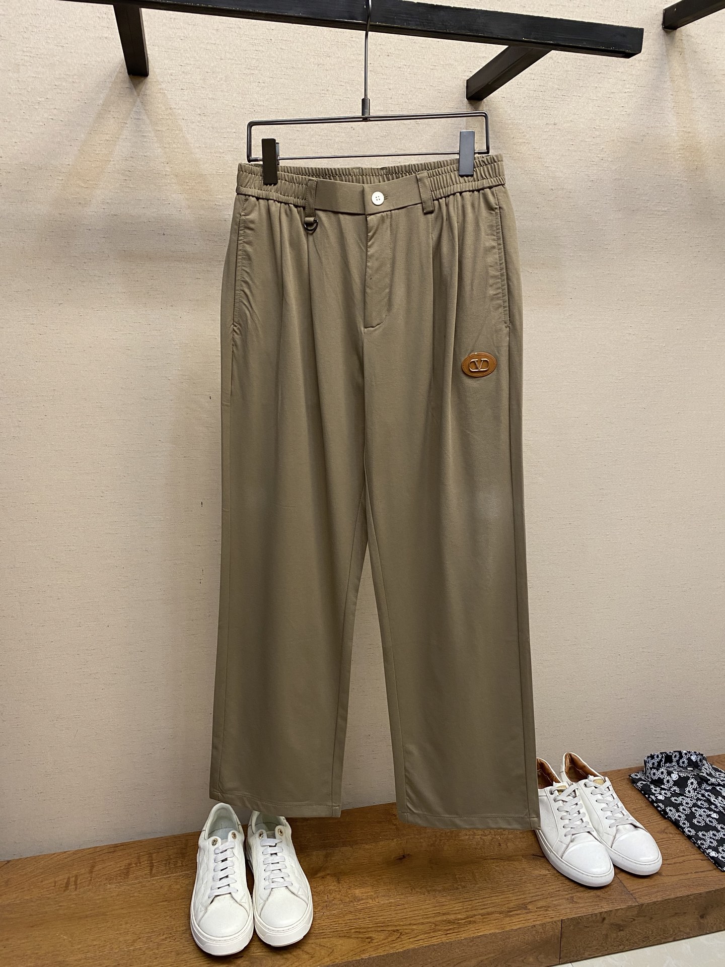 NO:159609,VLT...Coffee leather label men's elastic waist drawstring straight pants. This casual pants combines fashion and comfort. The brown tone is classic and versatile, and is adapted to a variety of styles. The unique elastic band and metal ring design at the waist are matched with simple white buckles, which not only ensure comfort while adding ingenuity to detail. The iconic oval leather logo is decorated with metal 