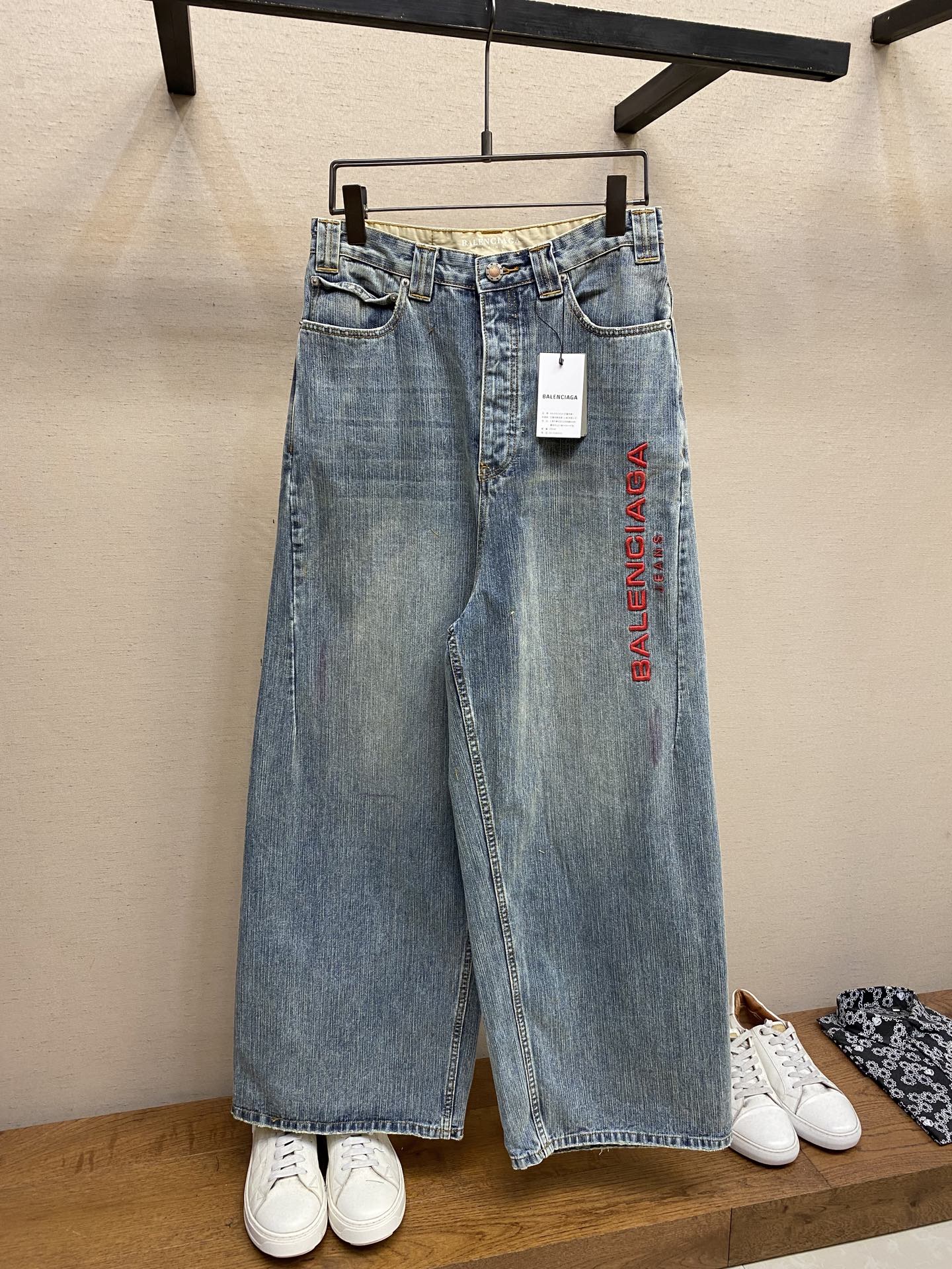 NO:467685,Balenciaga, BA Red-text embroidered denim trousers Original, 300; ring spindle denim, trouser leg embroidered with artwork, back jeans patch, mid-waisted design, front and back decoration with wash-water damage details, invisible button plackets, belt loops with pockets, full set of auxiliary materials equipped # ring spinning denim ring spinning denim is a special denim fabric made by ring spinning technology. Ring spinning is a relatively traditional spinning method, and the yarns are tight structure and high strength, making the denim more textured or unique appearance. The yarn fibers are tightly arranged, smooth and have high strength, giving the denim a delicate and flexible touch while maintaining wear resistance.  The yarns of ring spinning yarns are smooth on the surface and have good strength, but they are low in production efficiency and have a high cost. The denim made of this yarn may be stronger, have a better drape and have a unique texture. It is lighter and breathable than ordinary denims, and has a unique retro and old effect. # Use three-layer process for needle embroidery. The main body adopts precision needle embroidery technology; the embroidery is very fine and dense, with clear patterns and strong three-dimensional sense. The linen embroidery thread combined with encryption treatment, the embroidery body has a subtle matte visual texture; the embroidery effect is three-dimensional and full. The flat embroidery thread is uniquely designed, and the embroidery is very fine and dense; the overall stitching is fine and consistent, adding a sense of layering to the simple design. # The water slurry printing process incorporates penetration technology  The imported water slurry material is made of, and the water slurry printing contains strong penetration and color fastness, especially on cotton fabrics. The details of the printing are very well processed, without burrs and cross-border marks. After technical processing of the printing screen, the slurry can pass through the fabric, with strong permeability and clearly visible fabric texture. # Loose and old workwear style Reconstruct the classic workwear from a futuristic perspective, combining the thick and slim feeling of ring-spinned denim with technological functions. The hips are reserved for looseness, and the trouser legs are slightly conical from the thigh to the ankle, balancing lazy and neat lines. The back waist is embedded with elastic triangle inserts, which keep fit during dynamic movement and maintain a loose contour when static. Size XS-L,,balenciaga,alexander wang19860909Balenciaga,BA 红字刺绣牛仔长裤 原,300；环锭纱牛仔布、裤管饰以艺术作品刺绣、背面jeans贴饰、中腰版型设计、正面和背面饰以洗水破坏款细节、隐形纽扣门襟、腰带袢搭配口袋、全套辅料配备 # 环锭纱牛仔布 环锭纱牛仔布是一种特殊牛仔布料,通过环锭纺纱技术制成的.环锭纺纱是比较传统的纺纱方法,出来的纱线结构紧密,强度高,让牛仔布更有质感或者独特的外观.纱线纤维排列紧密、表面光滑且强度高,赋予牛仔布细腻柔韧的触感,同时保持耐磨性. 环锭纺纱的纱线表面光滑,强度好,但生产效率较低,成本较高.这种纱线制成的牛仔布可能更结实,有更好的垂感并且具有独特的纹理.相比普通牛仔布更轻盈透气,且具备独特的复古做旧效果. # 采用挨针绣三层工艺处理 主体采用精密挨针绣工艺；刺绣非常精细针法绵密,图案清晰且线条感和立体感强.亚麻材质绣线结合加密处理,绣体具有微妙的哑光视觉质感；刺绣效果立体饱满.平绣的挨针走线独特设计,刺绣非常精细针法绵密；整体针脚细密,精细度质感一致,为简约设计增添了层次感. # 水浆印花工艺融入渗透技术 采用进口水浆材质,水浆印花含有渗透力色牢度较强,尤其在全棉面料上效果更好.印花之间细节处理非常到位,无毛边及过界痕迹.经过对印刷网版进行技术处理,浆料能够透过到织物上,渗透性强且面料纹路清晰可见. # 宽松做旧工装版型 以未来主义视角重构经典工装,将环锭纱牛仔布的粗粝感与科技功能结合.臀部预留松量,裤腿从大腿至脚踝呈微锥形,平衡慵懒感与利落线条.后腰嵌入弹性三角插片,动态活动时保持贴合,静态时维持宽松轮廓. 尺码XS-L,,balenciaga,alexander wang,Men's clothing