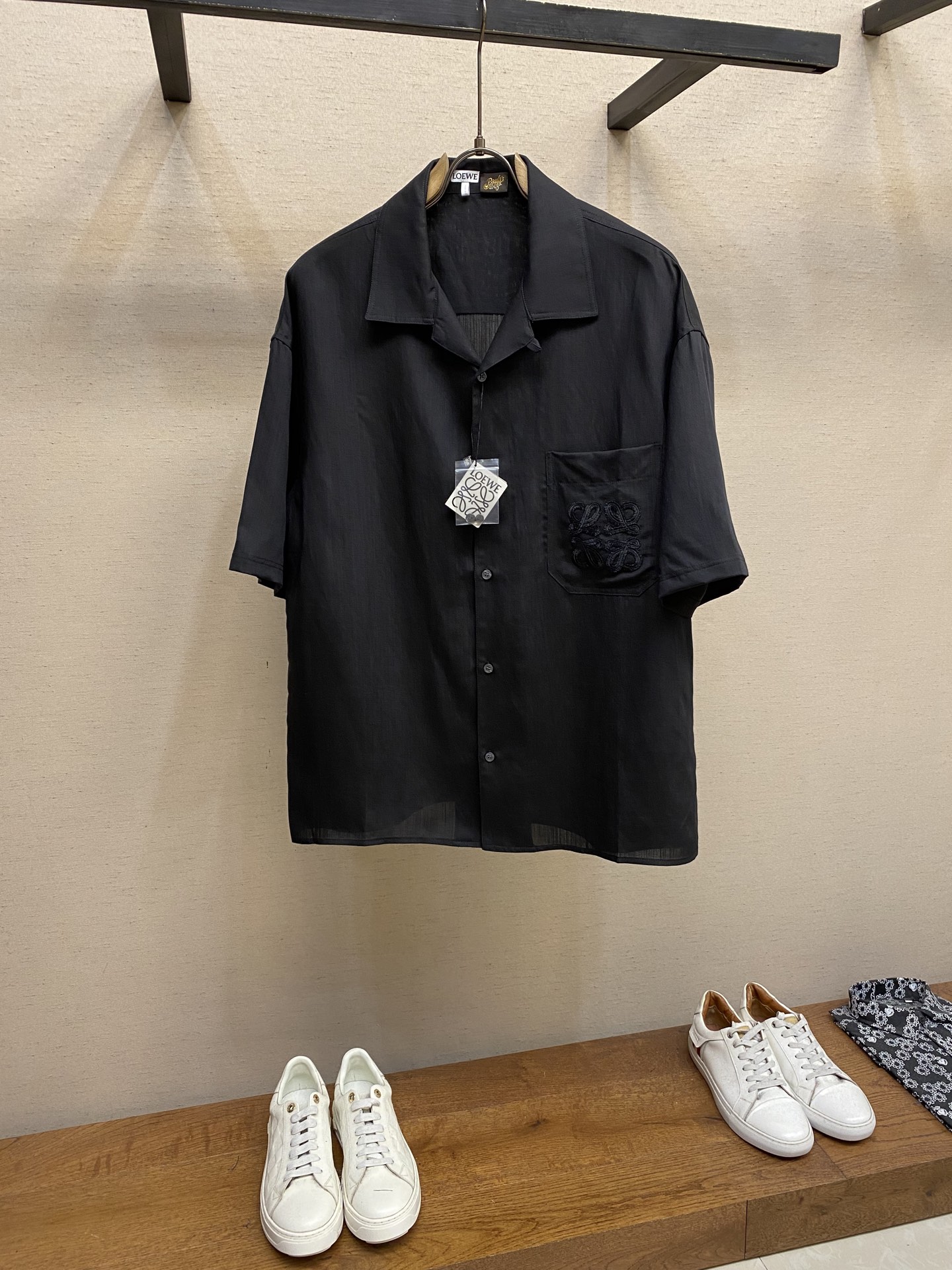 NO:481731,Loewe, embroidered linen short-sleeved shirt fabric selection: Viscose fiber is fused with linen, and fiber interlocking is achieved through air-flow spinning technology. The smooth drape of viscose fiber neutralizes the rough texture of flax, and the skinny support of flax makes up for the deformable shortcoming of viscose fiber. The high moisture absorption rate of viscose fiber is linked to the porous fiber structure of flax to form a dual-channel sweating system. The wrinkle resistance and drape feel are combined, reflecting the characteristics given by the fusion of the two fibers. Crafts The Anagram totem in the chest patch pocket adopts the implicit hook-and-needle embroidery process, and the extremely thin filament thread evolves a precision matrix of 320 needles/CM on the linen substrate, which resonates with the natural texture of the fabric. The inner lining is implanted with a tensile mesh substrate to ensure that the embroidery remains flat as before after frequent use. The auxiliary materials are washed with water, and the collar mark is one to one restored by Anagram totem.  Size S-XL, loewe,shirts,T-shirt,alexander wang19860909Loewe,绣花亚麻短袖衬衫 面料选择 以粘胶纤维与亚麻融合,通过气流纺纱技术实现纤维互锁,粘纤的柔滑垂坠感中和亚麻的粗粝肌理,亚麻的骨感支撑力弥补粘纤易变形的短板.粘纤较高的吸湿率与亚麻的多孔纤维结构联动,形成双通道排汗系统.抗皱性与垂坠感兼得,体现两种纤维融合赋予的特性. 工艺 胸前贴袋的Anagram图腾,采用隐式勾针刺绣工艺,以极细丝线在亚麻基底上演化出320针/CM的精密矩阵,与布料天然纹理同频共振.内衬植入抗拉伸网纱衬底,确保频繁使用后刺绣依然平整如初. 辅料一比一水洗标  一比一领标  一比一还原Anagram图腾 尺码S-XL,,loewe,shirts,T-shirt,alexander wang,Men's clothing